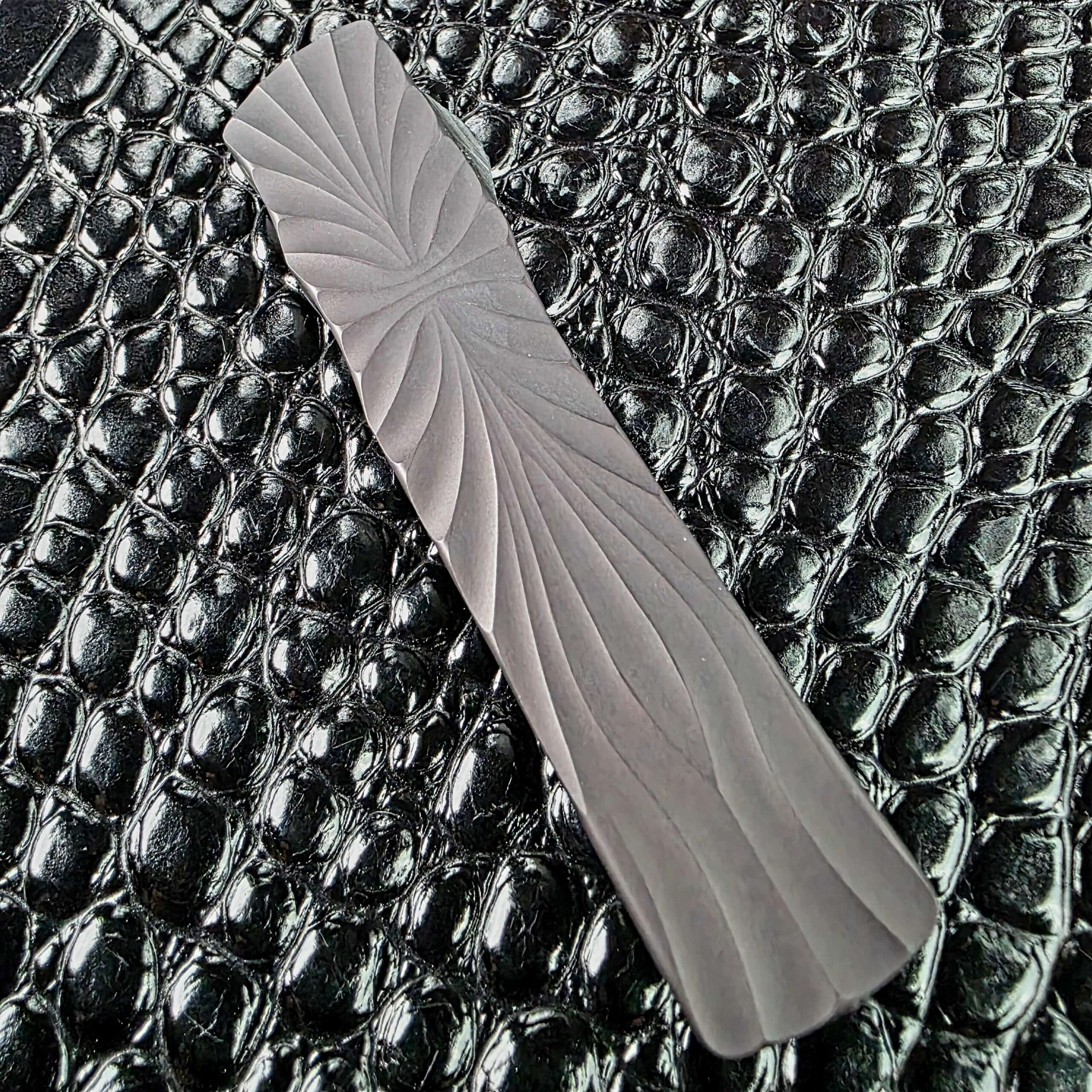 Twisting milled flutes on the DLC-coated titanium handle face of the Brian Tighe Tighe Twist OTF
