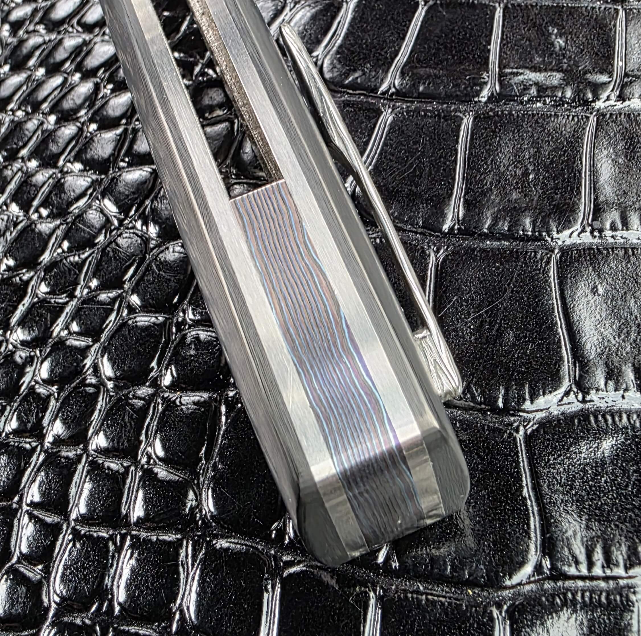 Spine view of the Glenn Are Hovin Koda showing the layered backspacer between polished titanium frame edges