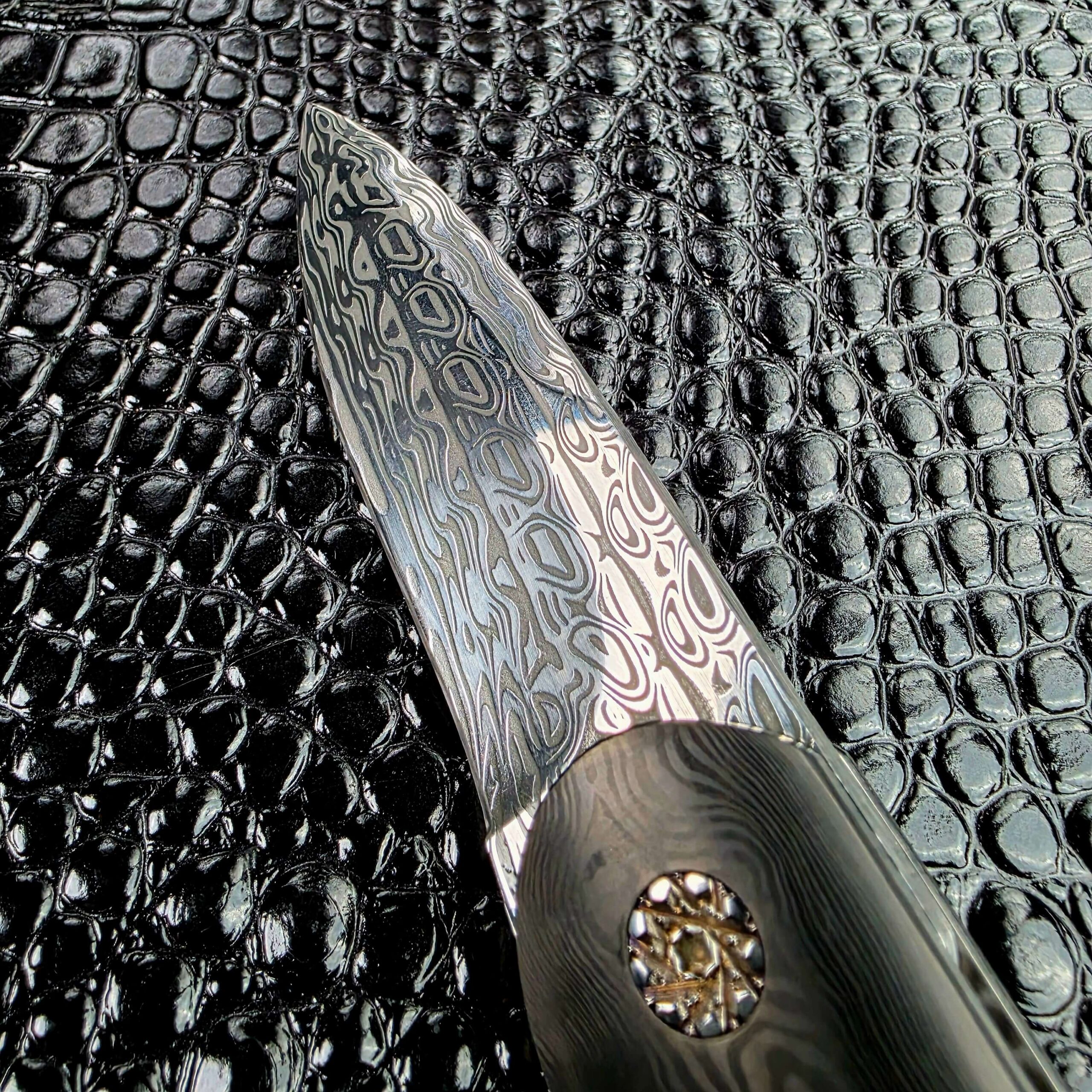 Faceted custom pivot on the open Glenn Are Hovin Koda catching light against layered carbon fiber
