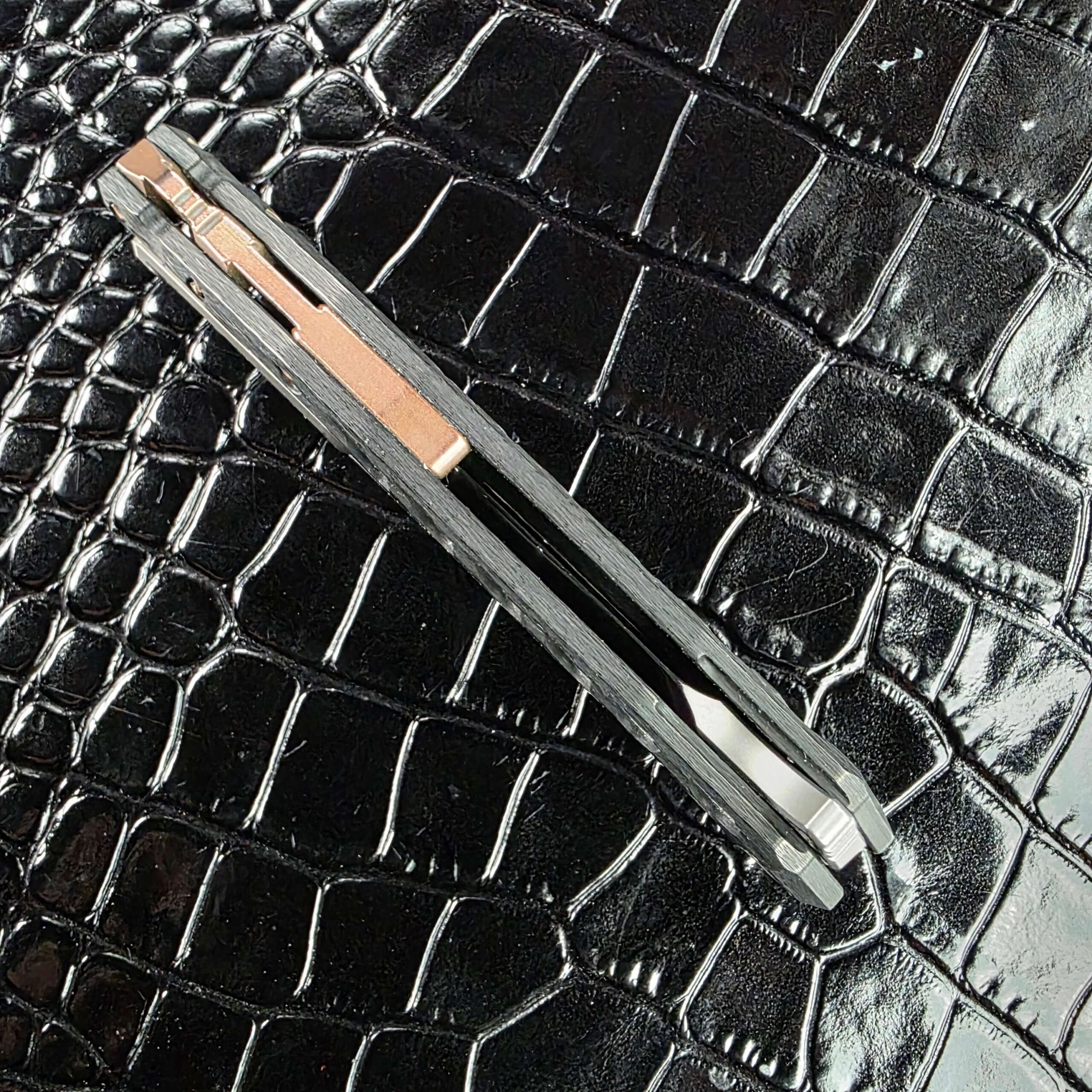 Spine profile of the closed Marfione Custom Sigil showing the copper backspacer and blade spine together