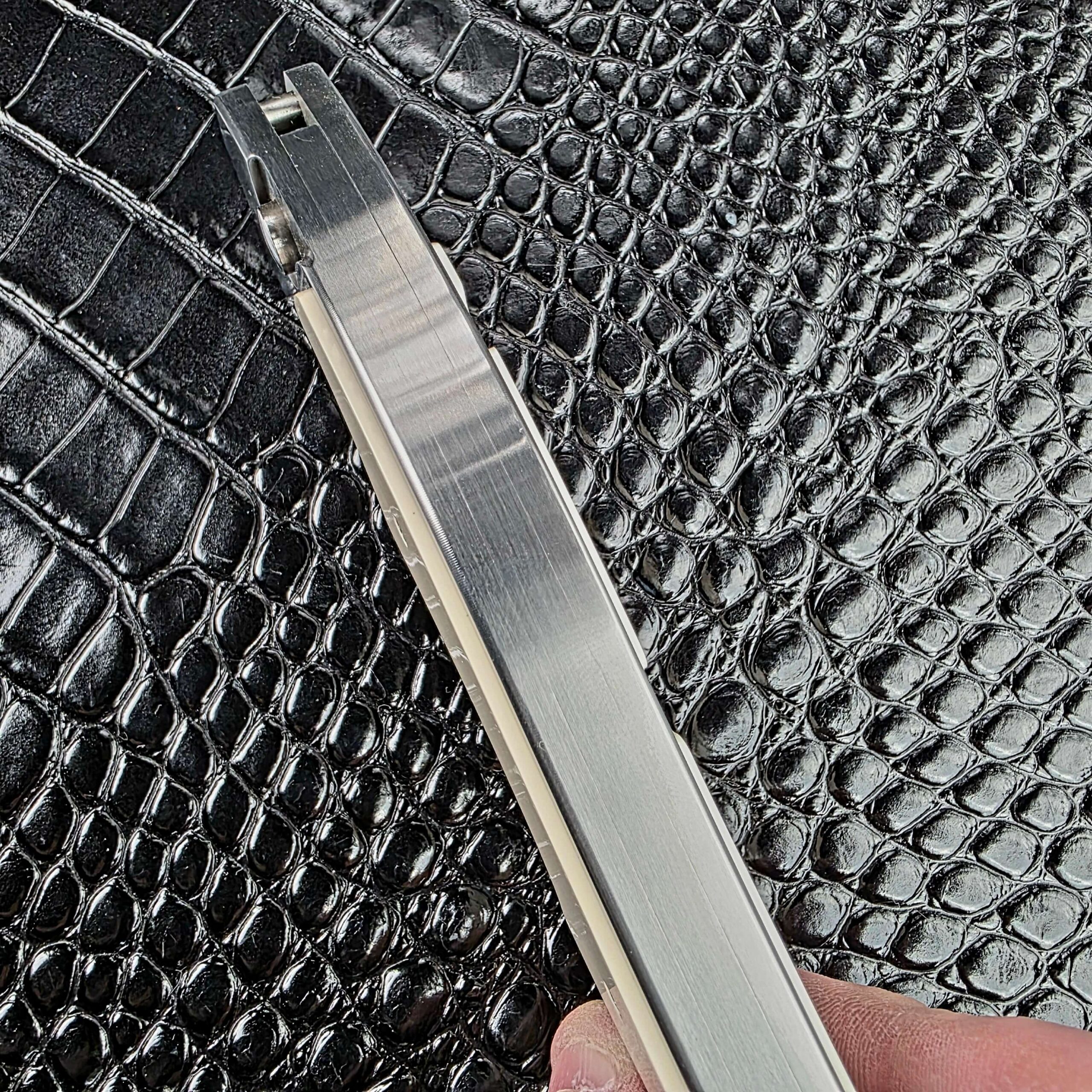 Spine view of the closed Reese Weiland Large Rastor showing the stainless steel frame