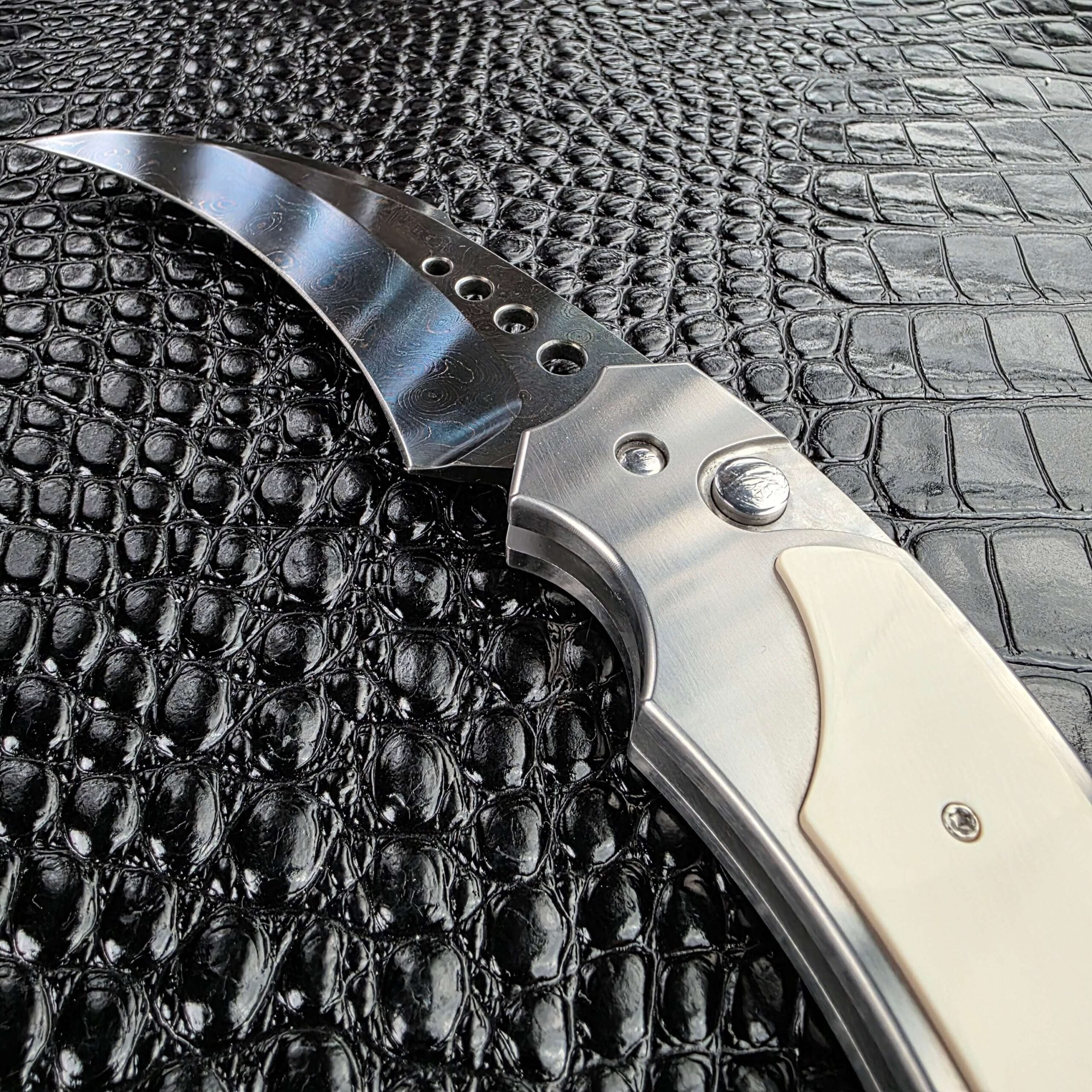 Reese Weiland Large Rastor open at an angle showing the bolster, button and damascus blade
