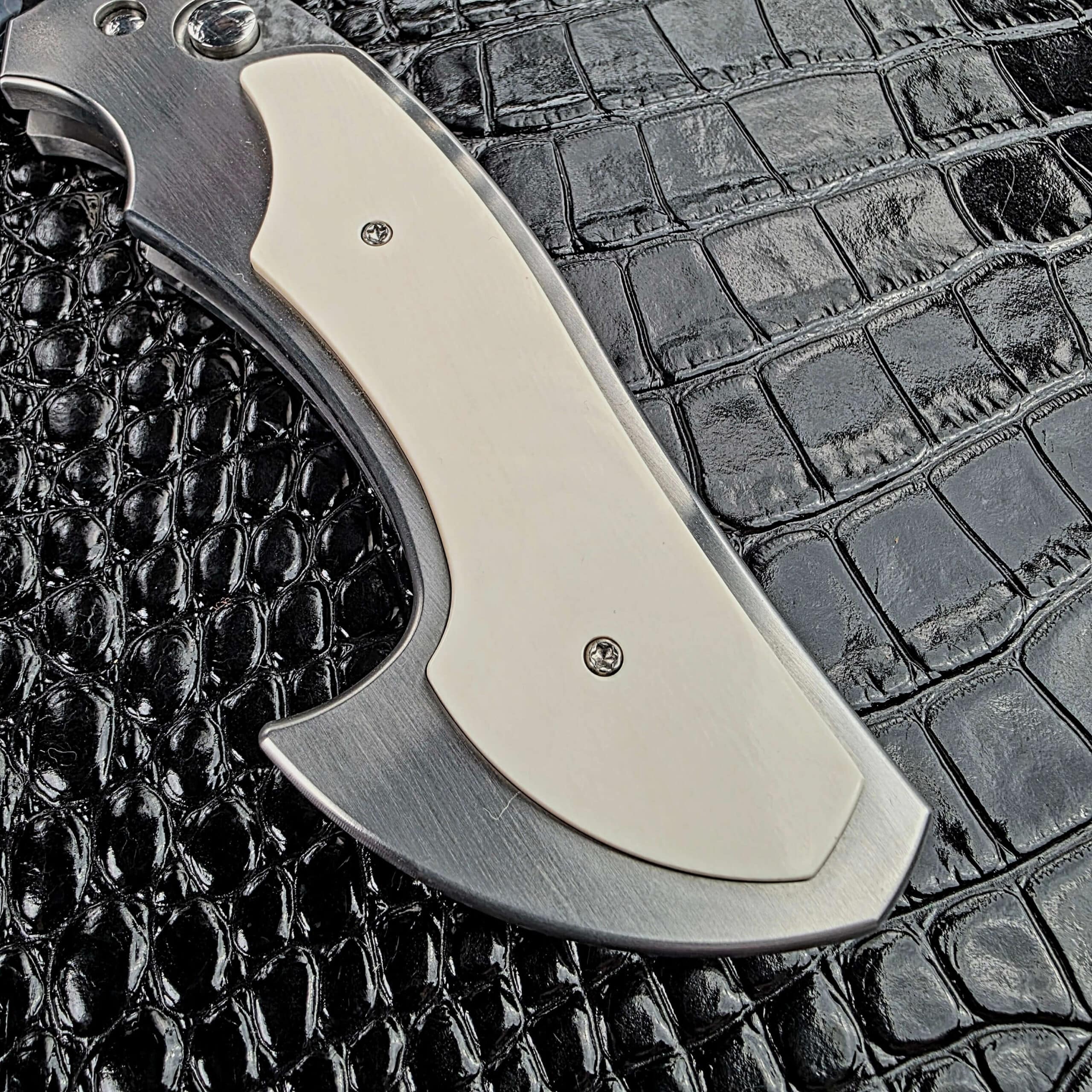 White mammoth tusk scale set into the stainless frame of the Reese Weiland Large Rastor