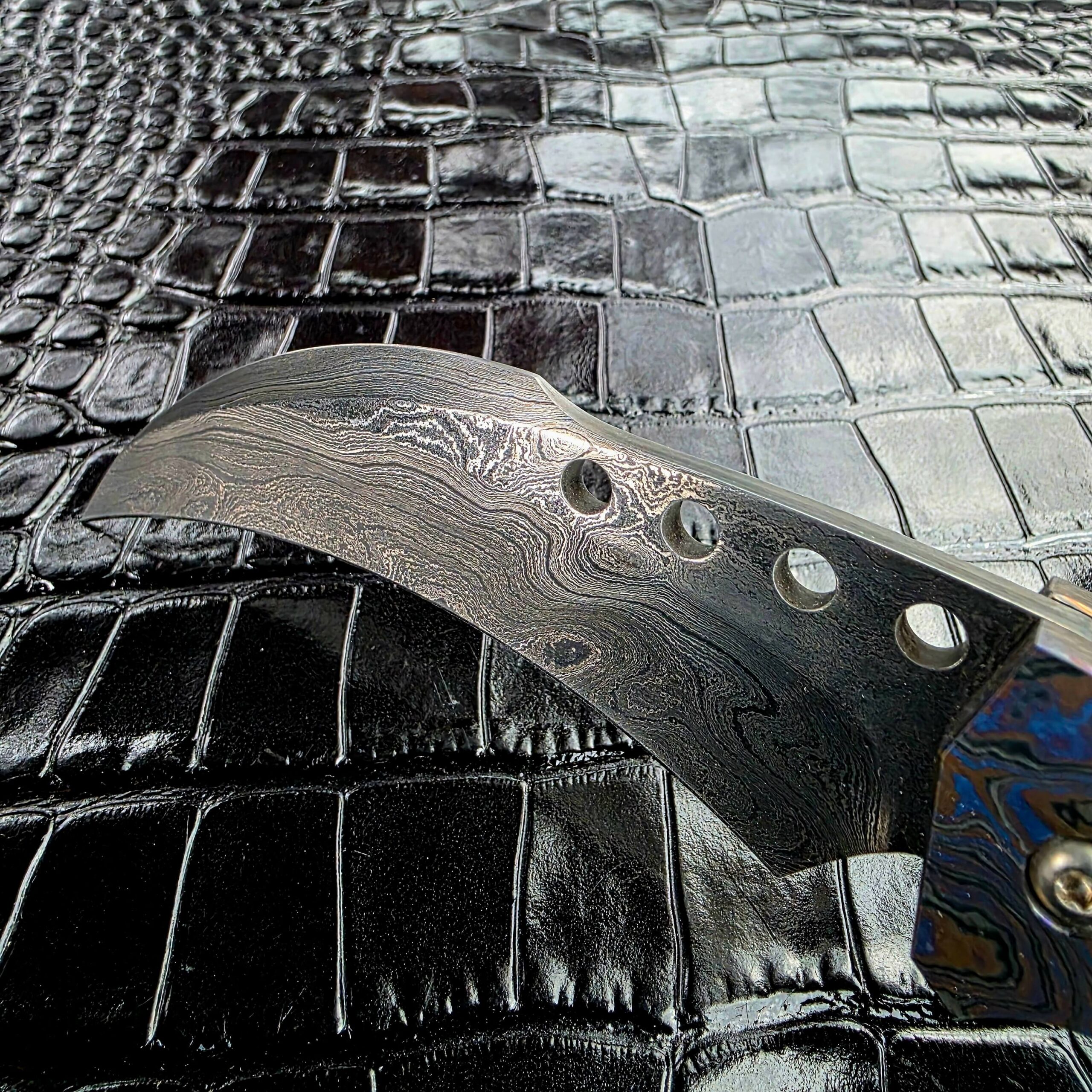 Low angle across the grind of the Reese Weiland hawkbill damascus blade