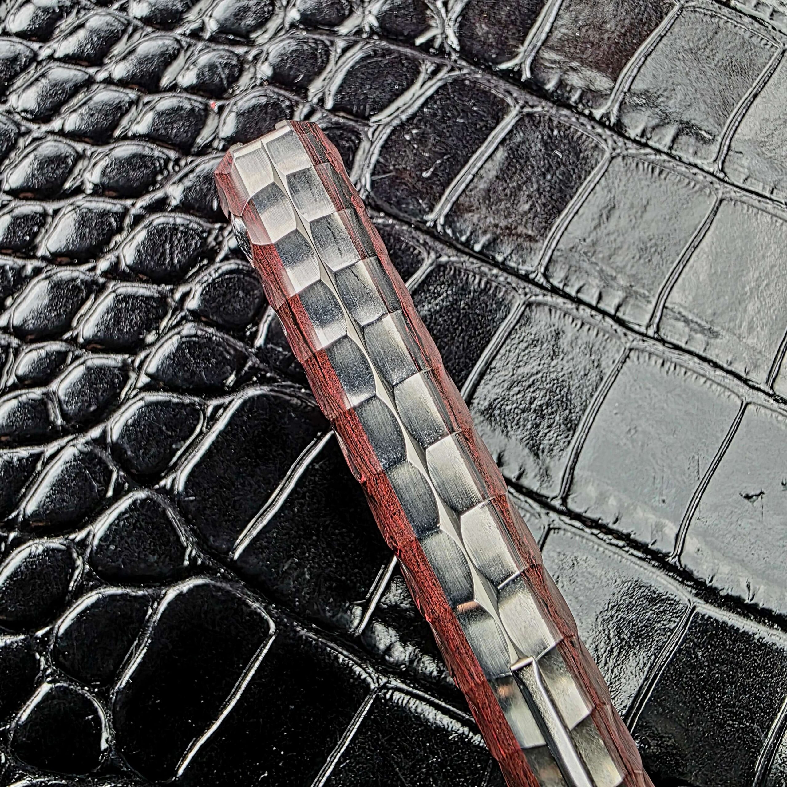Titanium backspacer along the spine of the Rockstead NEHAN between ebonite scales