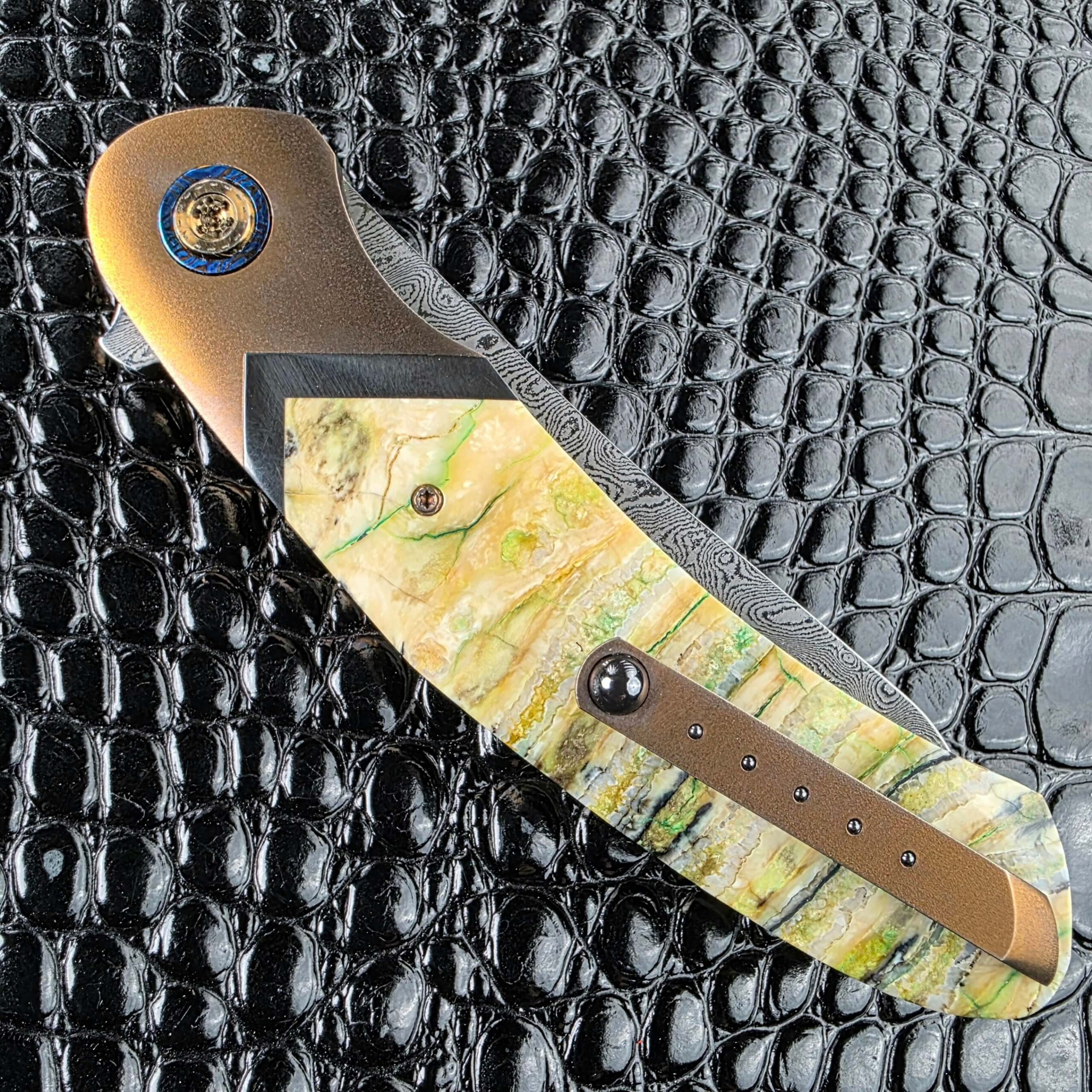 Pocket clip with five inlaid dots against the mammoth tooth scale of the Andriy Mozil Model 22-26