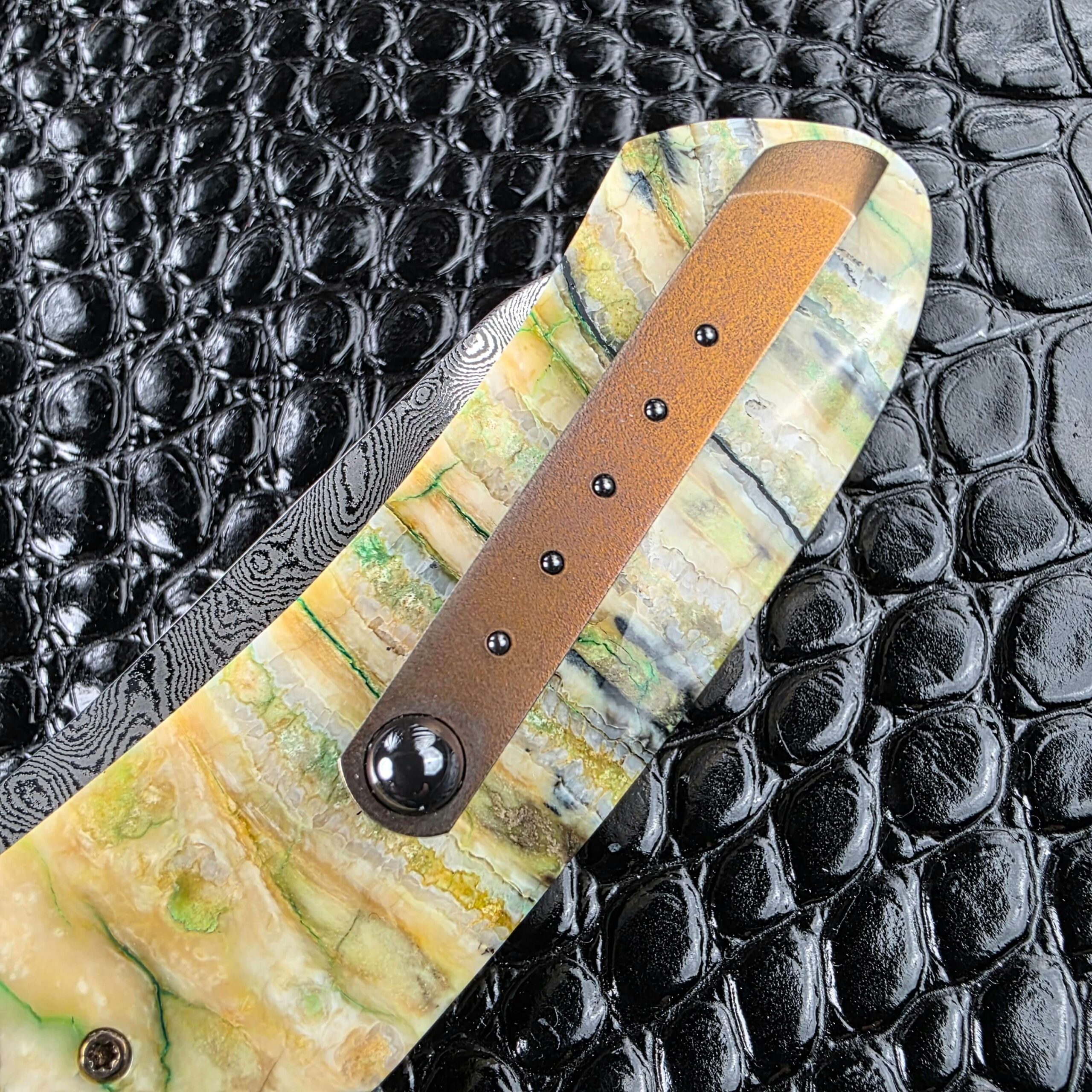Pocket clip with five inlaid dots against the mammoth tooth scale of the Andriy Mozil Model 22-26