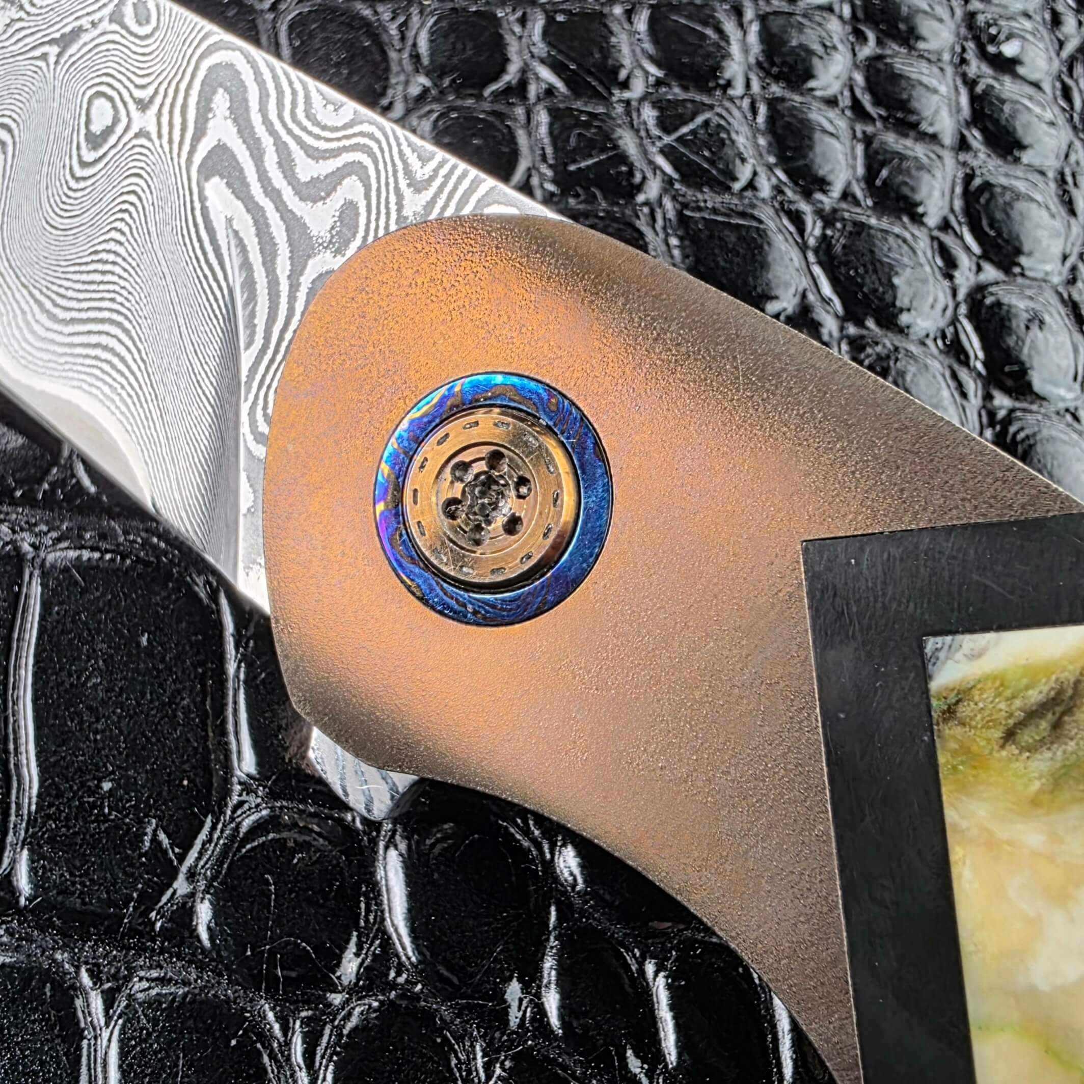 Timascus pivot collar in blue and violet on the zirconium bolster of the Andriy Mozil Model 22-26