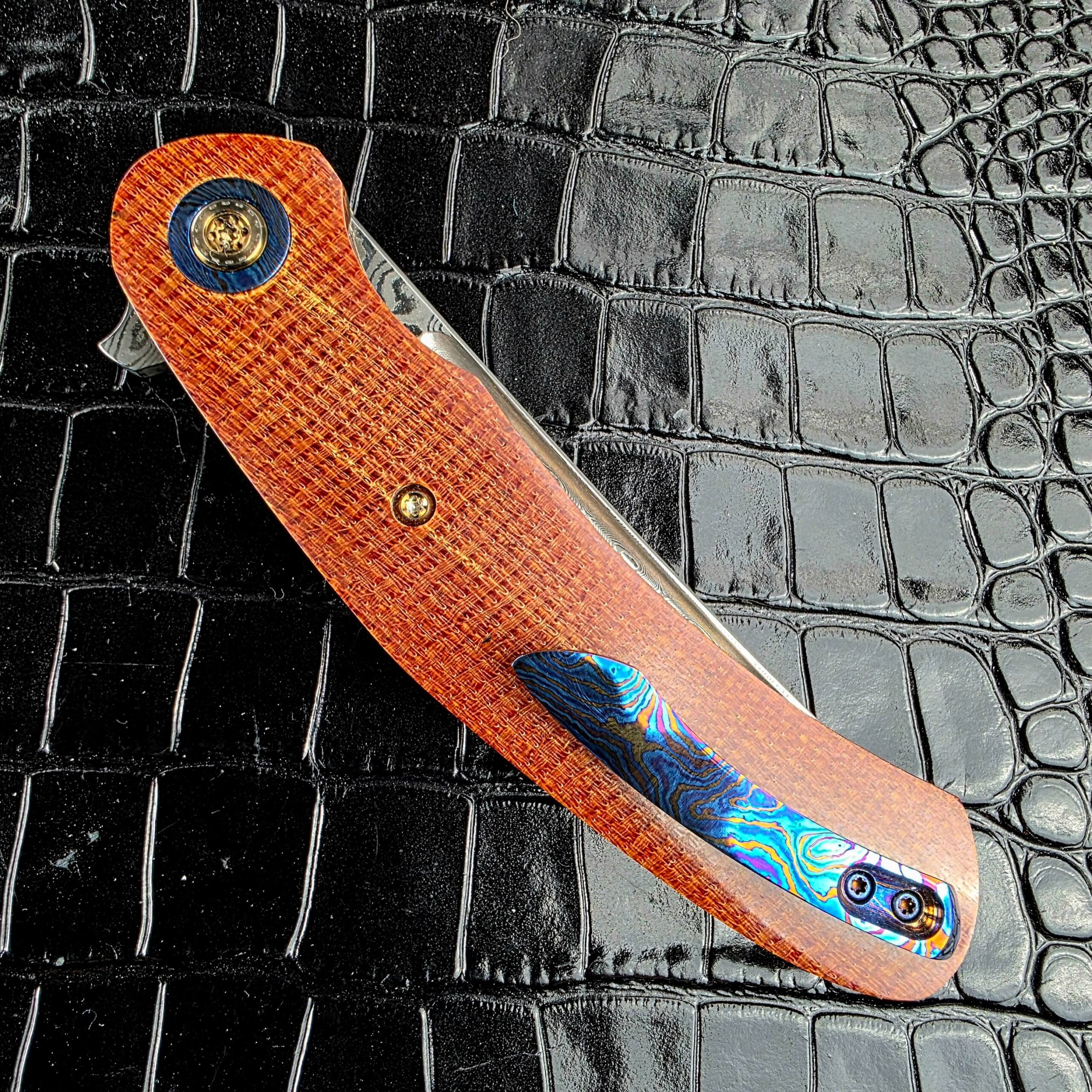 Andriy Mozil Model 23-26 closed, showing the Timascus bolster against canvas Micarta