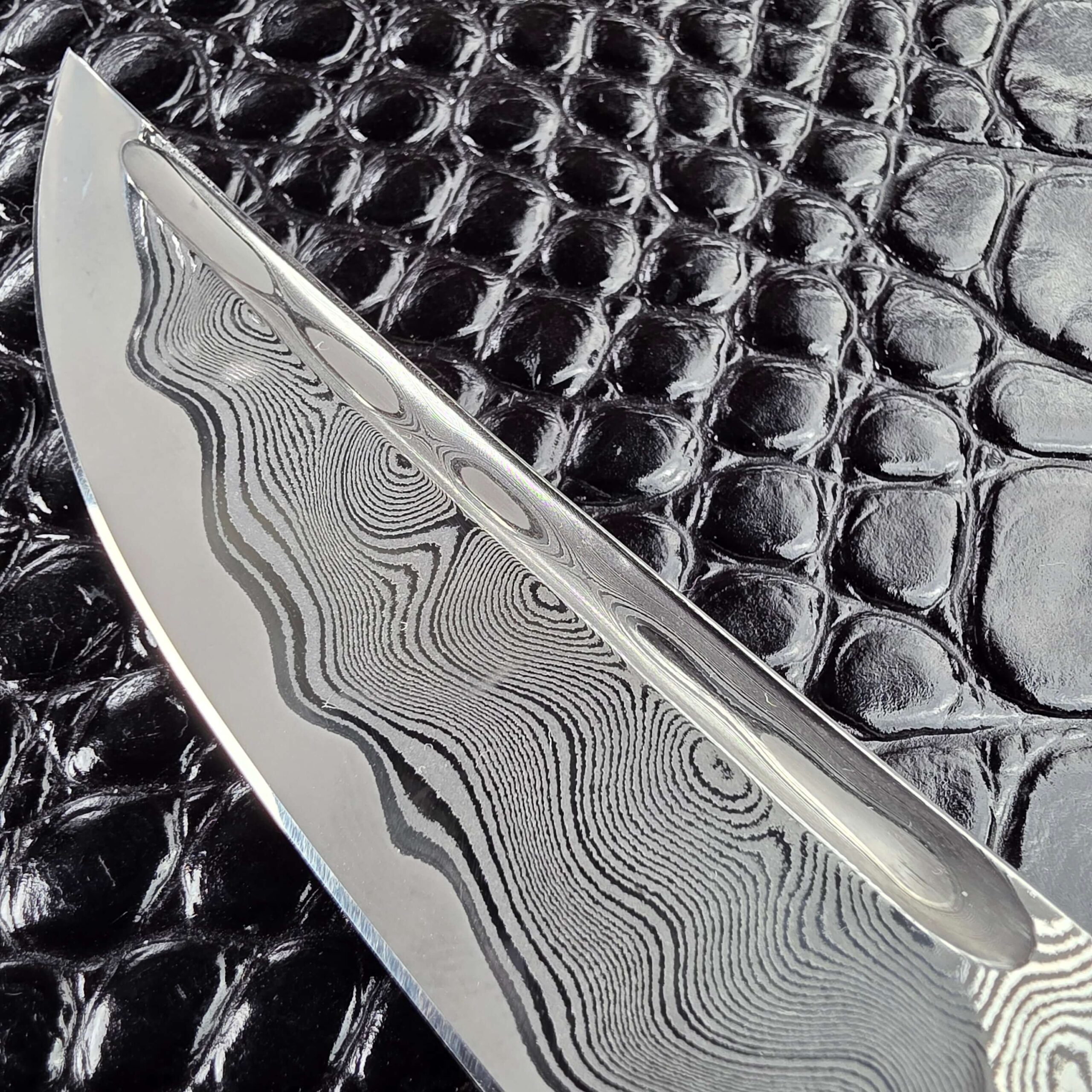 Stainless Damascus cladding on the Andriy Mozil Model 23-26 blade
