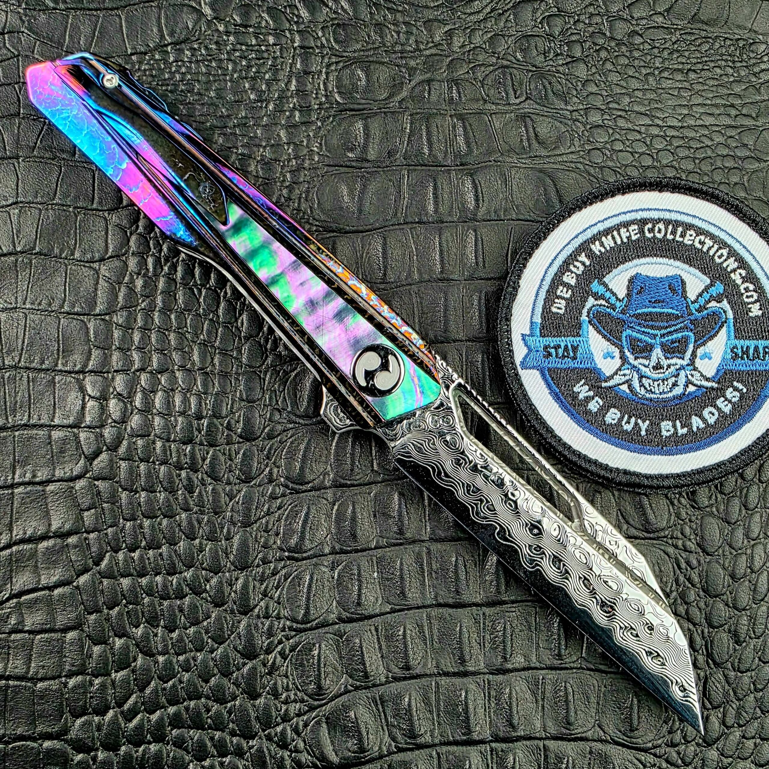 Dew Hara Kabuki open on its clip side with the Cosmic Storm pocket clip and We Buy Knife Collections patch