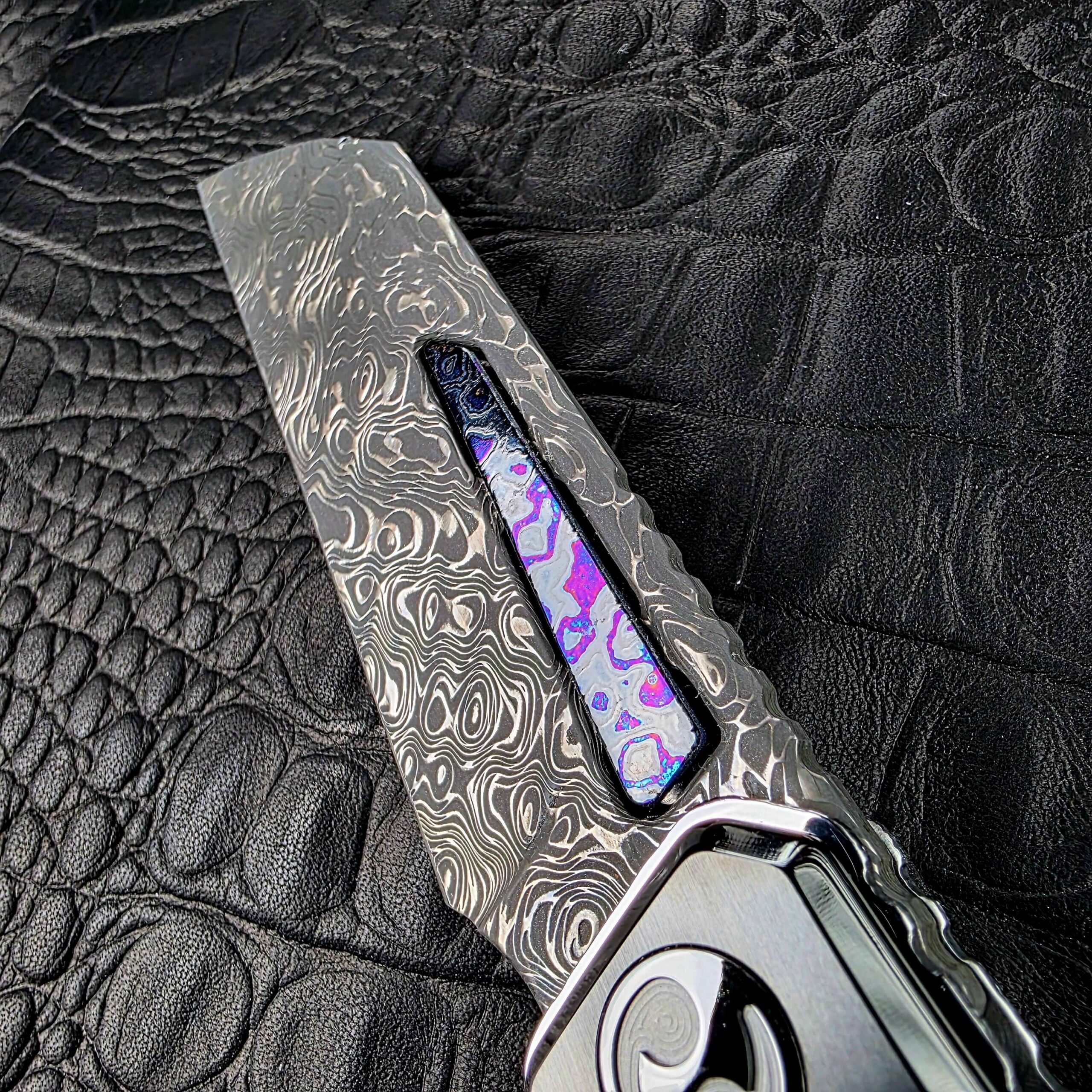 Macro of the Zircuti inlay in the fuller of the Dew Hara Seismic Damascus Ray blade