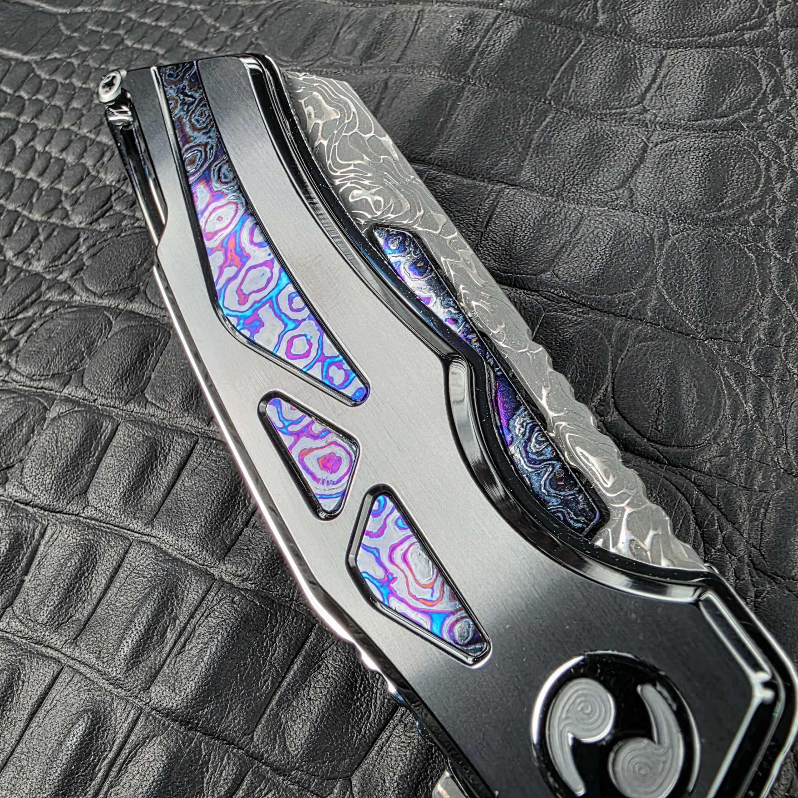 Zircuti inlays set into the DLC Titanium frame of the closed Dew Hara Seismic Damascus Ray, show side