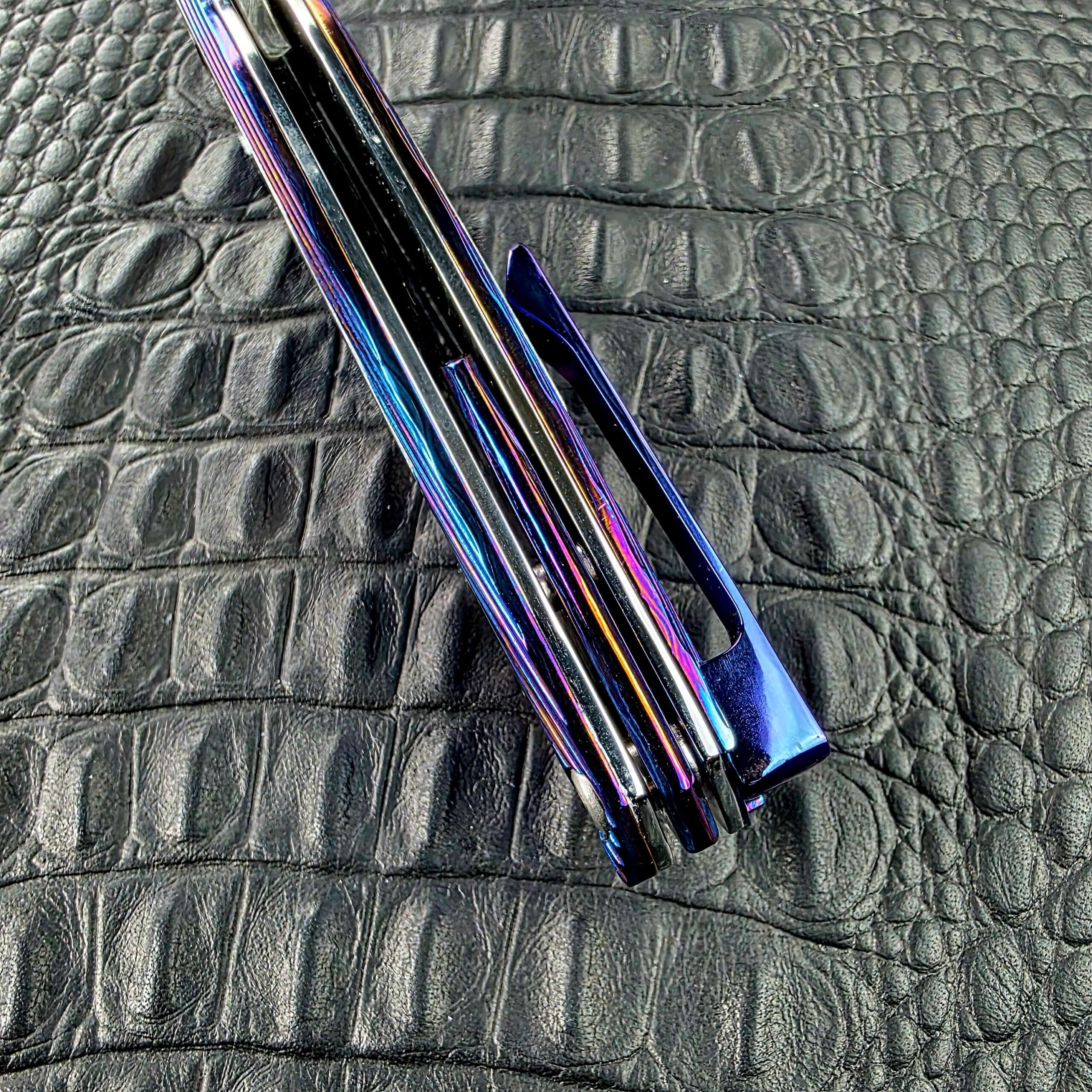 Butt end and spine of the closed Dew Hara Sharktooth Damascus METEOR with the Titanium pocket clip