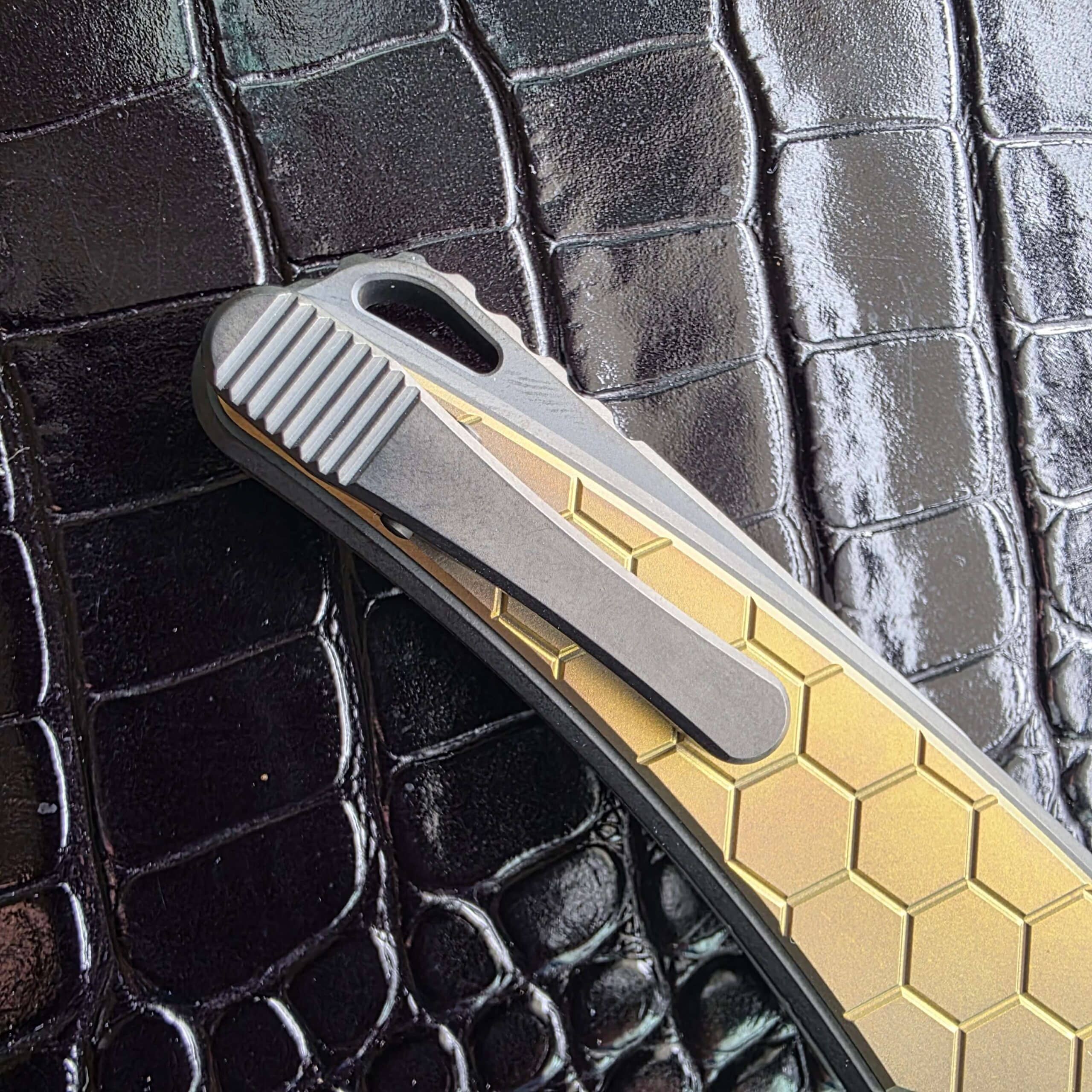 Macro of the tumbled titanium Hawk Gripclip with deep scalloped jimping and lanyard hole