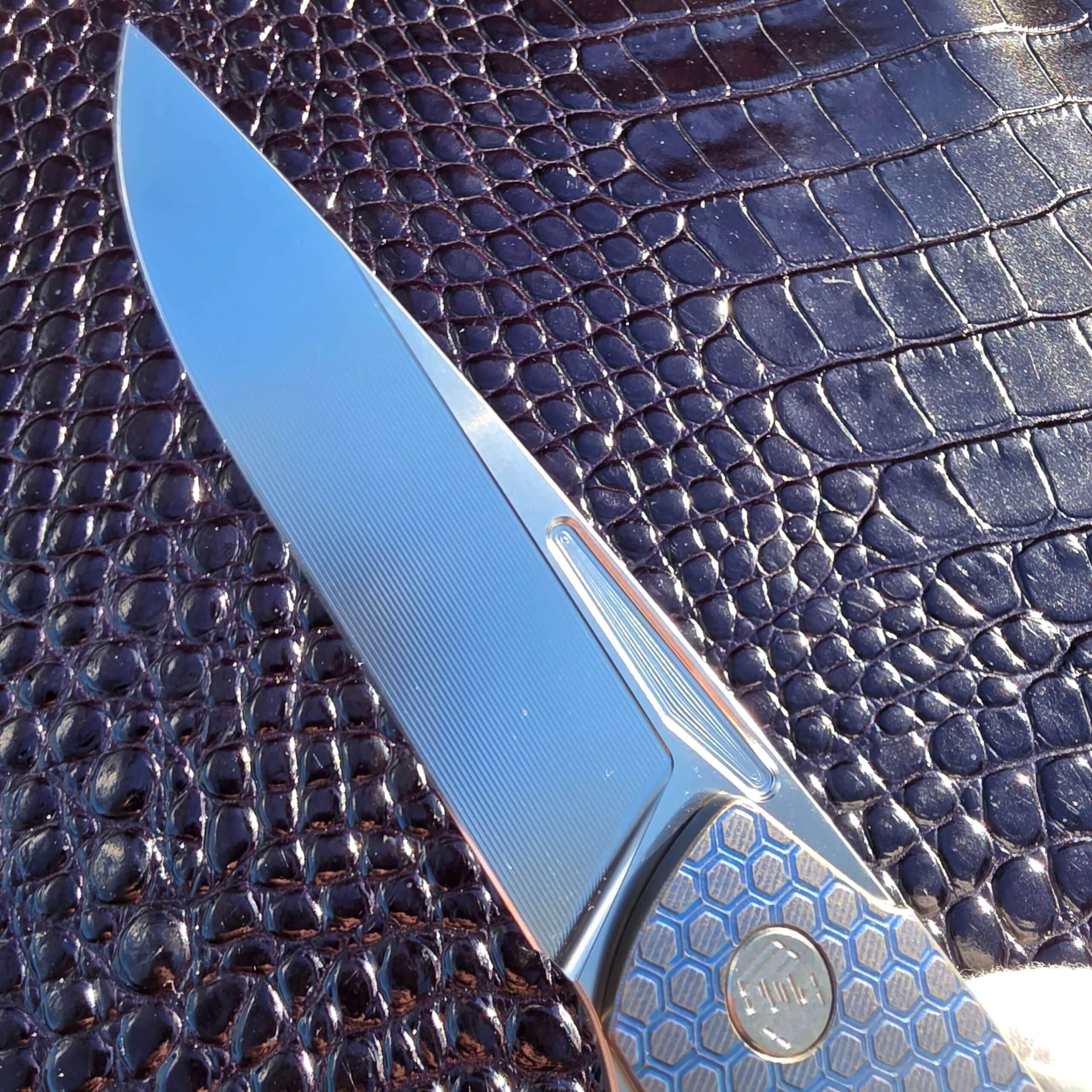 Macro of the RWL-34 drop point blade on the Hog House Honeycomb showing micro-milled flats and the step to the bevel
