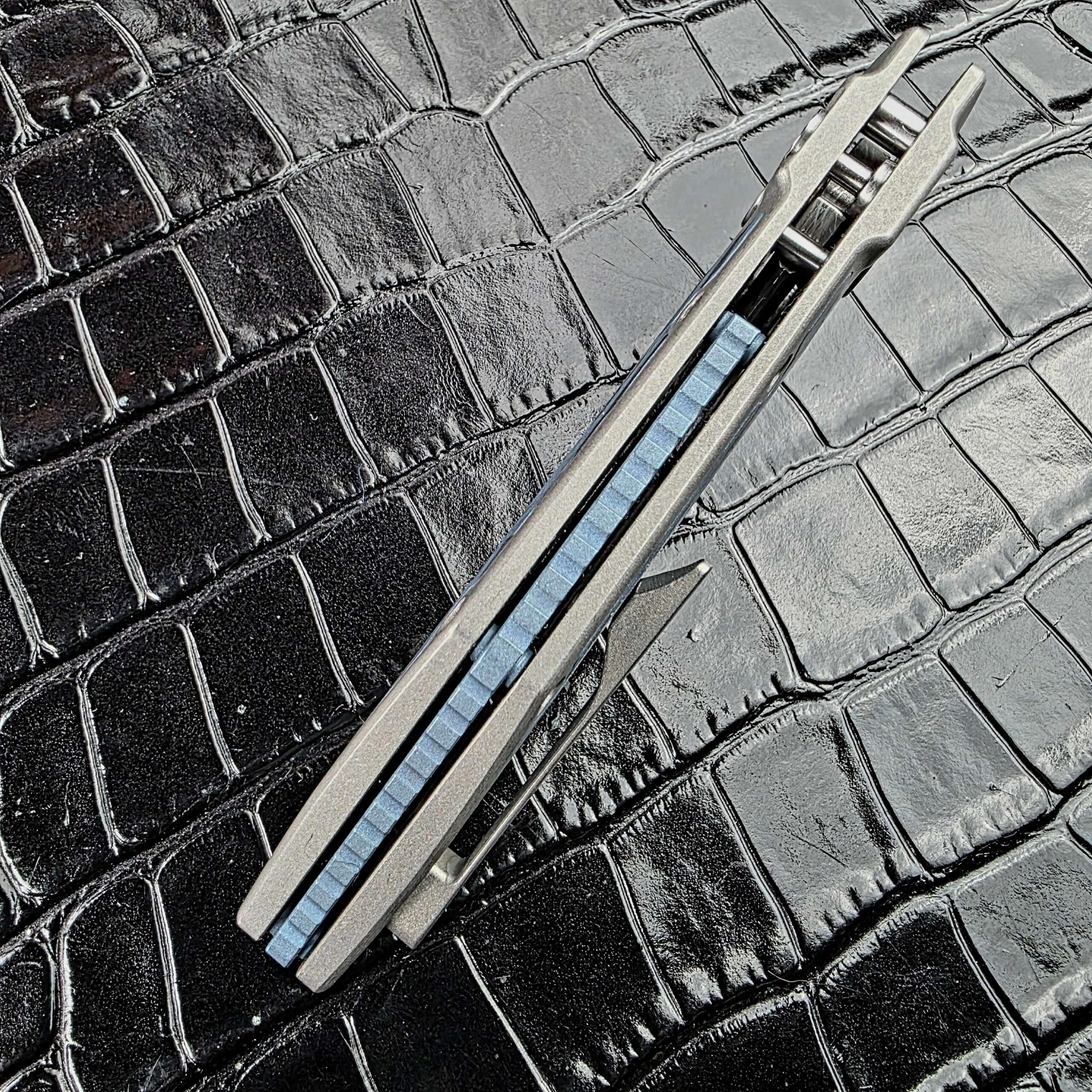 Spine view of the closed Hypercut Dharma with the jimped blue Titanium backspacer between the frame halves