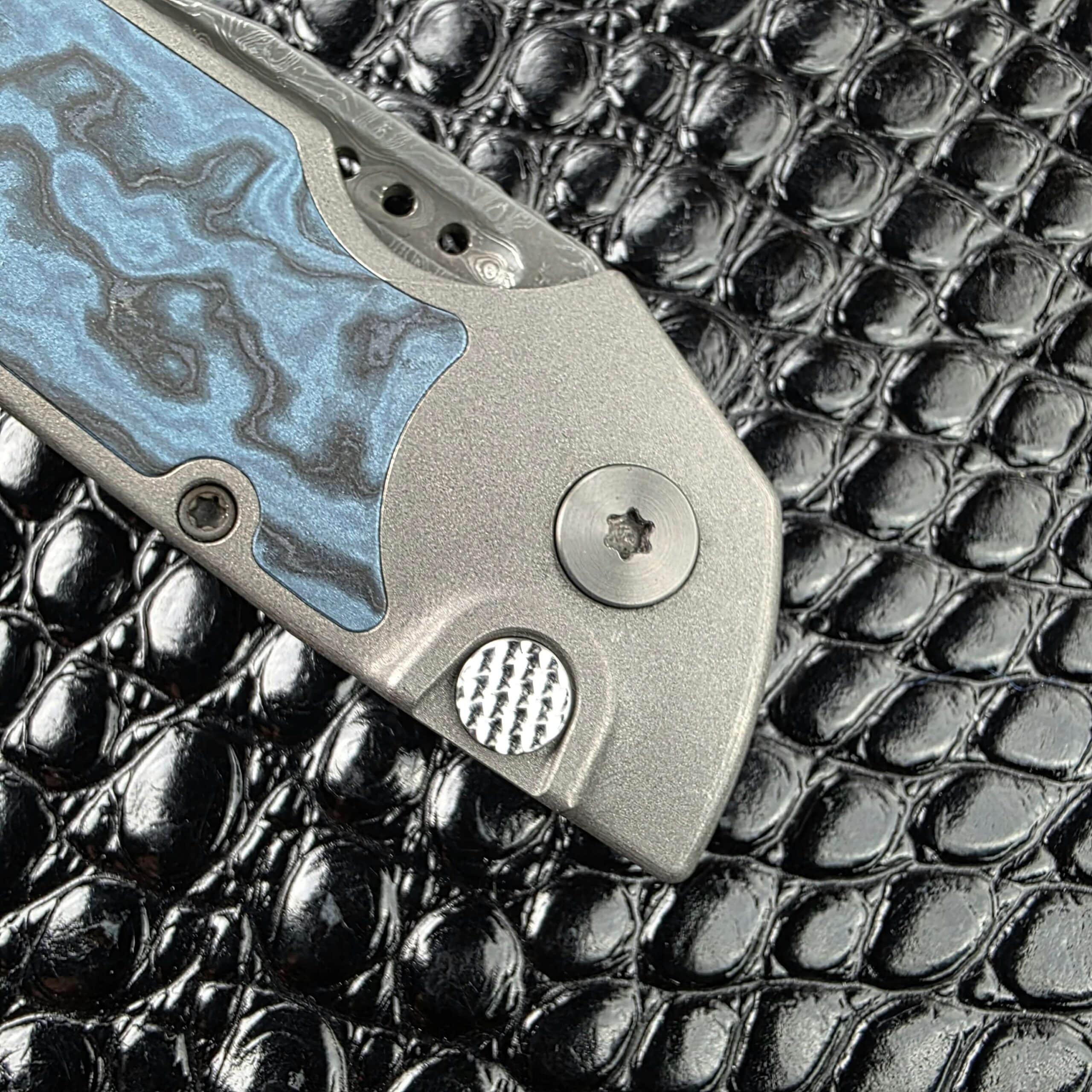 Macro of the textured push button and Zirconium pivot on the show side of the Hypercut Dharma