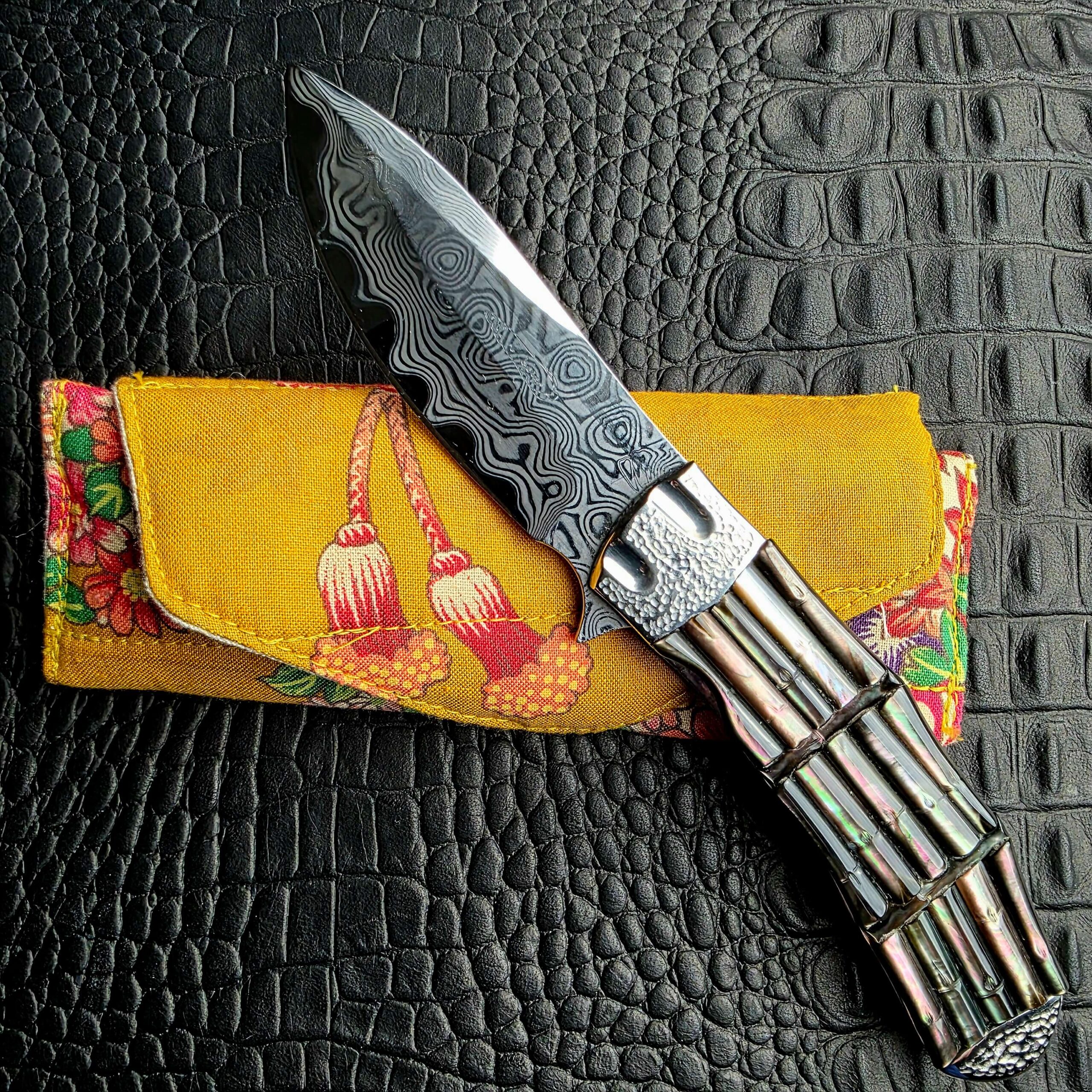 Koji Hara Take Flipper resting on its antique kimono fabric pocket pouch