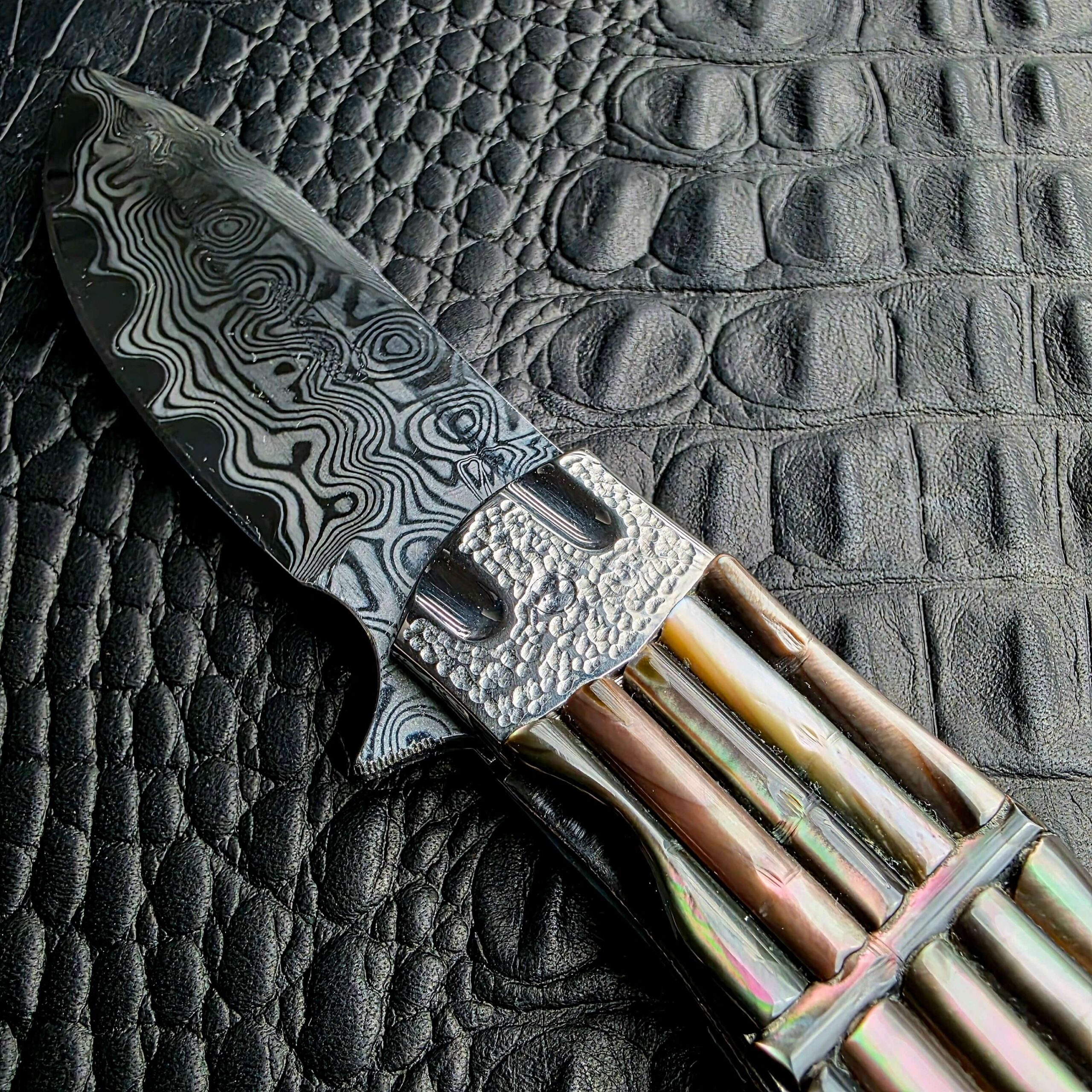 Raindrop Damascus blade and front tsuchime bolster of the Koji Hara Take Flipper, show side