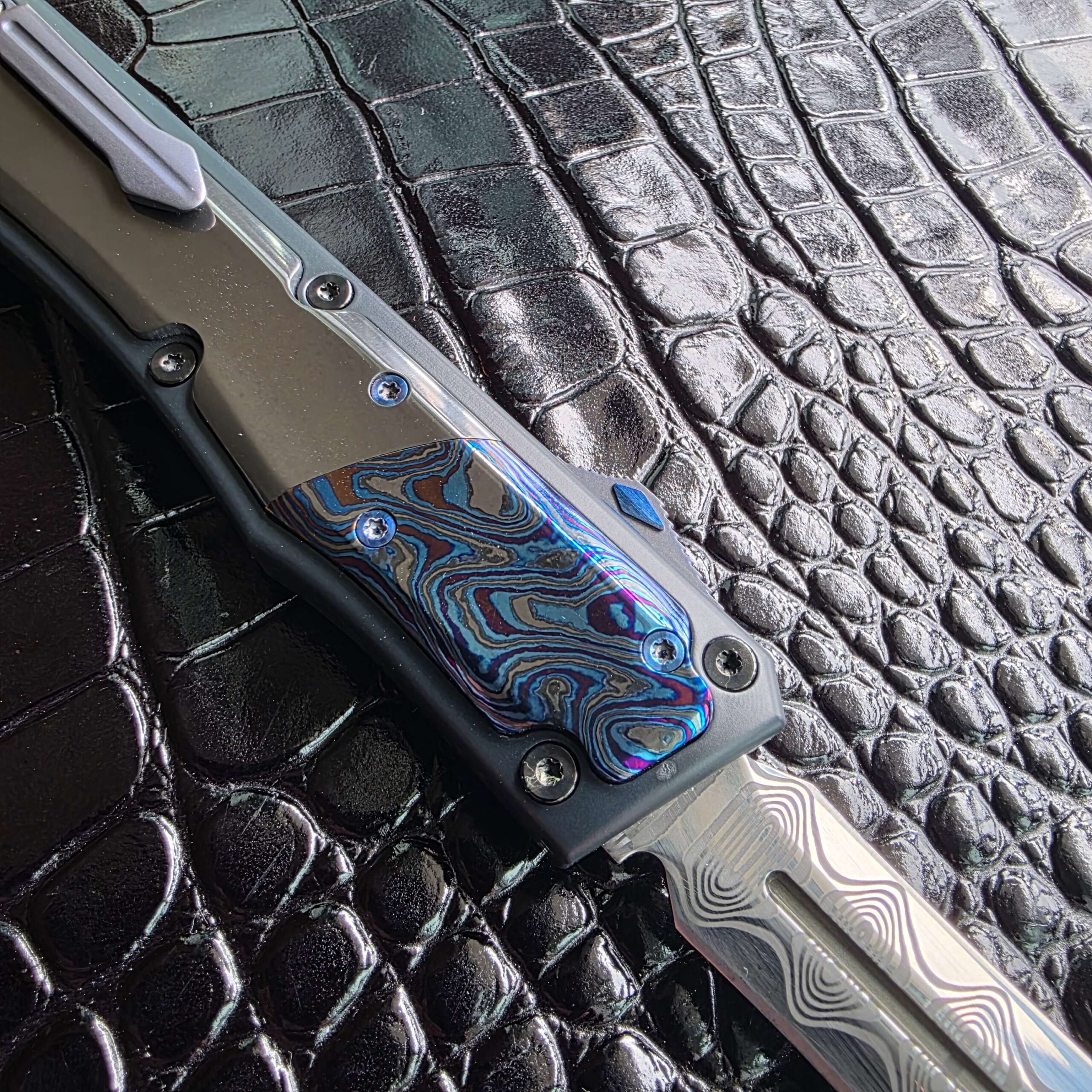 Three-quarter view of the Patrick Famin GOTF Mini open on the clip side with clip, bolster and thumbslide in frame