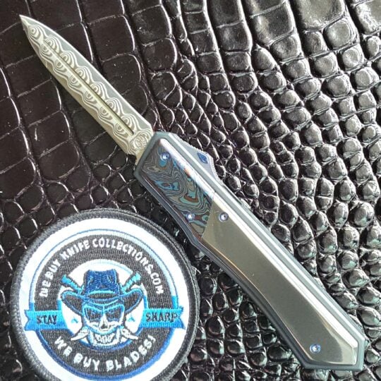 Patrick Famin GOTF Mini open on the show side with the Damasteel Damacore dagger deployed, We Buy Knife Collections patch in frame