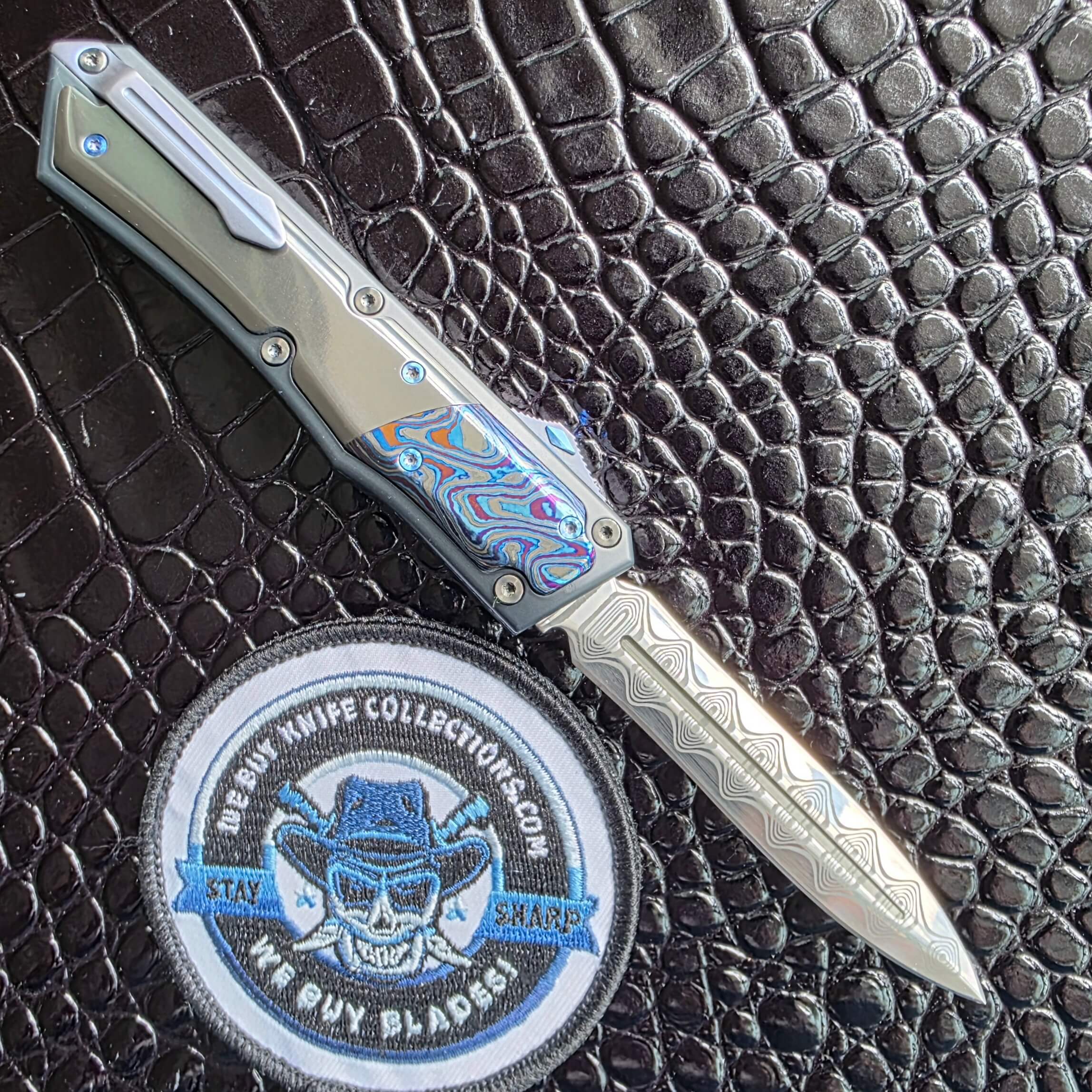 Patrick Famin GOTF Mini open on the clip side showing the sculpted titanium pocket clip, We Buy Knife Collections patch in frame