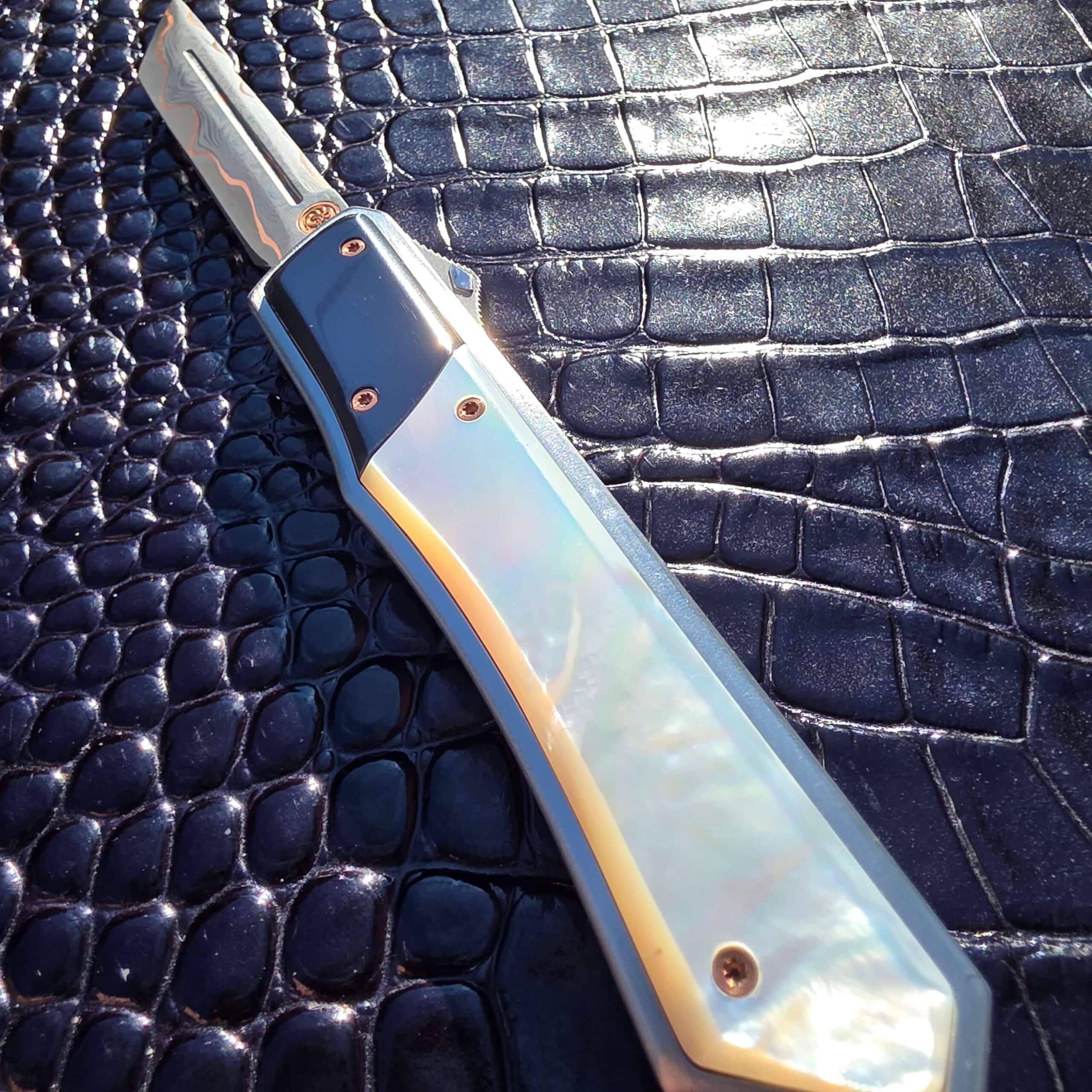 Patrick Famin Mother of Pearl G.O.T.F. Mini caught mid-deployment, blade emerging straight out the front of the handle