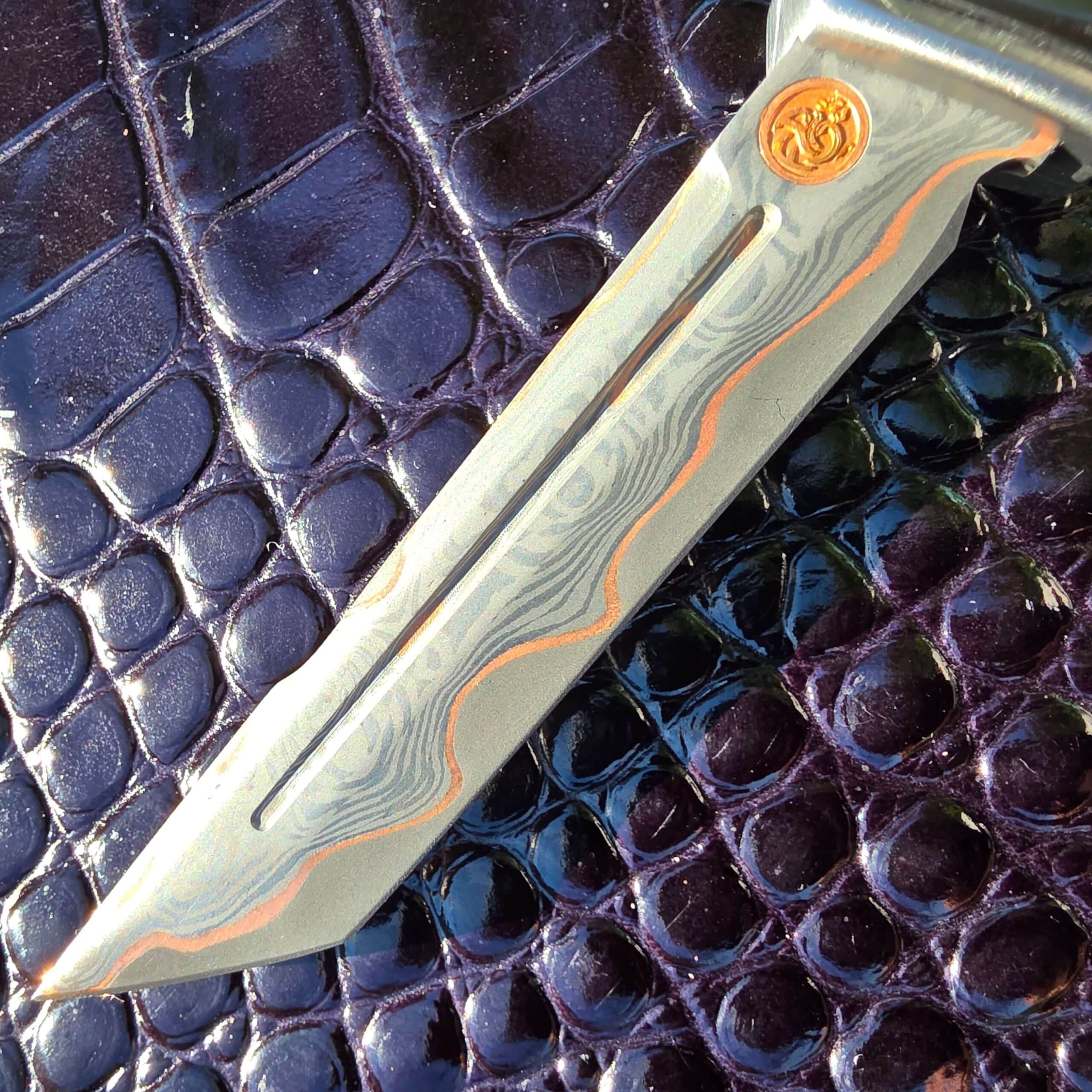 Macro view of the copper maker’s medallion on the Patrick Famin Mother of Pearl G.O.T.F. Mini against the zirconium bolster