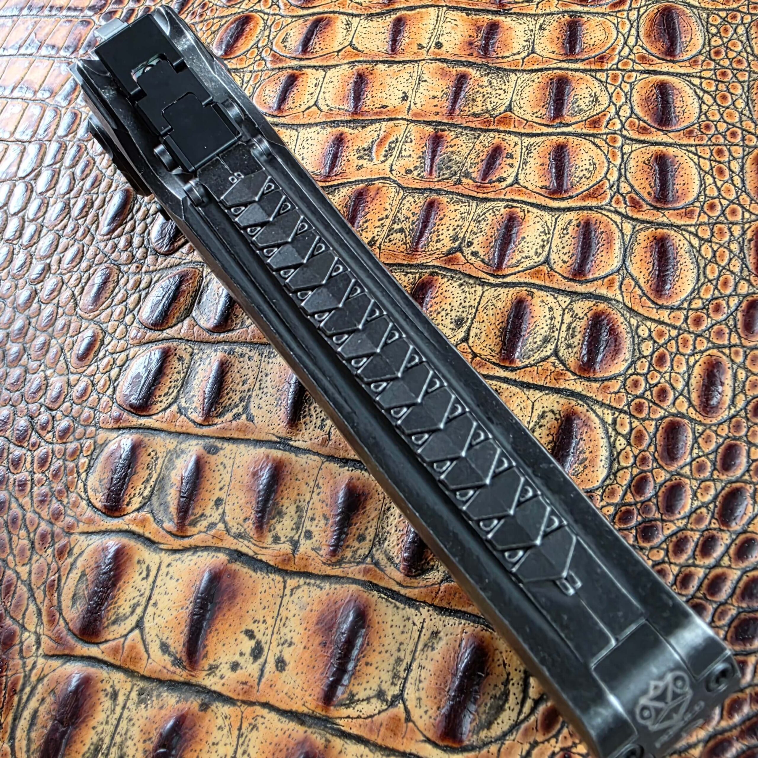 Full-length view of the Poikilo Blade AL-Khem spine showing faceted relief machining and the POIKILO mark