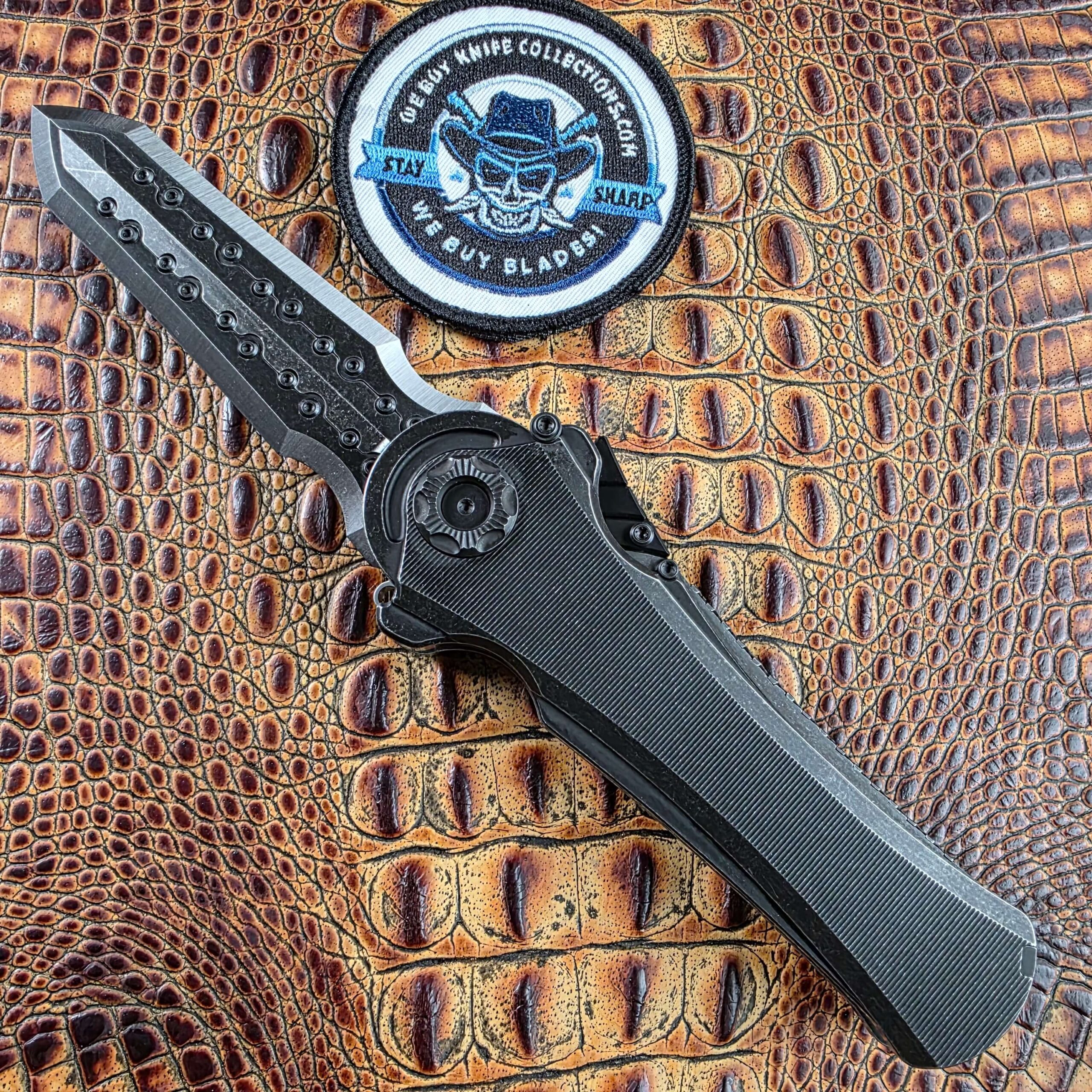 Poikilo Blade AL-Khem Standard 02 open on the show side in standard configuration, We Buy Knife Collections patch in frame