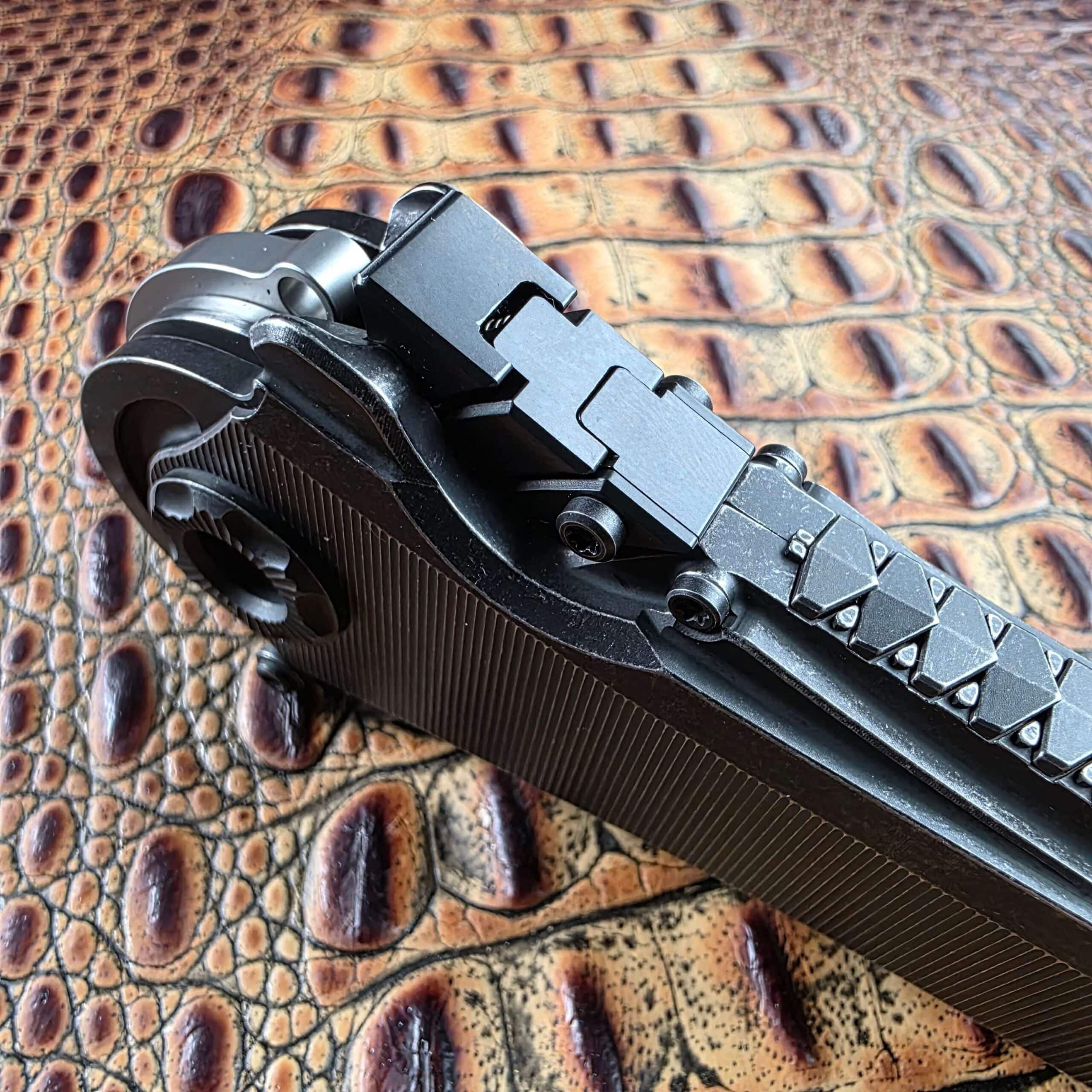 Three-quarter view of the Poikilo Blade AL-Khem segmented spine slider in its channel, knife closed