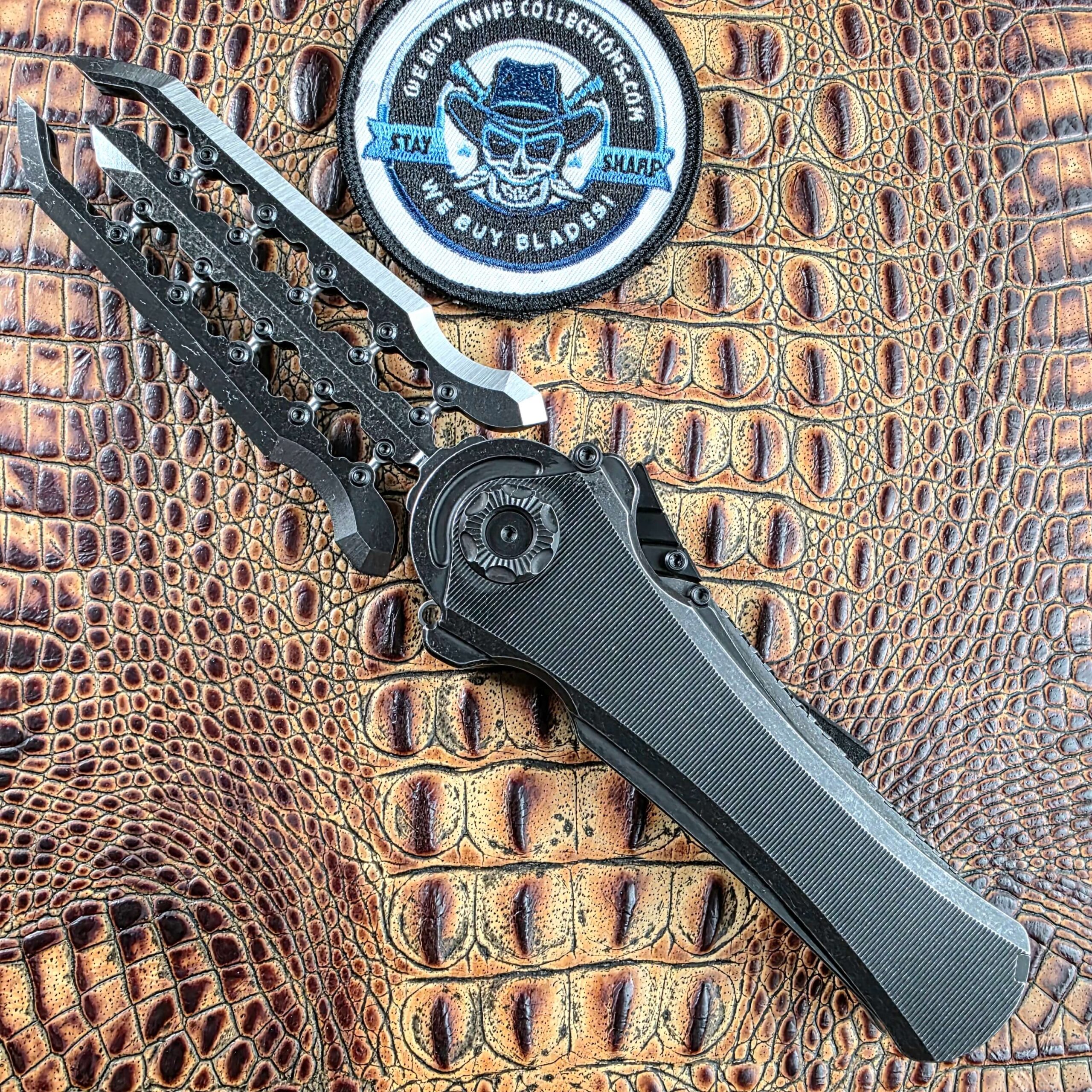 Poikilo Blade AL-Khem with the blade expanded into three parallel sections, open on the show side, We Buy Knife Collections patch in frame