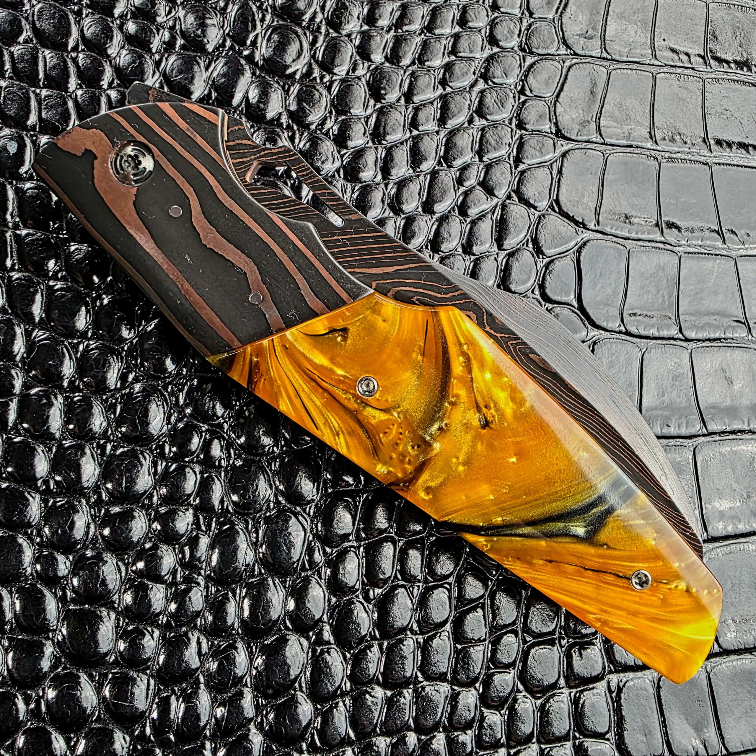 Closed Reese Weiland Harpy on its reverse side, with the Honey Hive Acrylic scale and Copper Damascus bolster