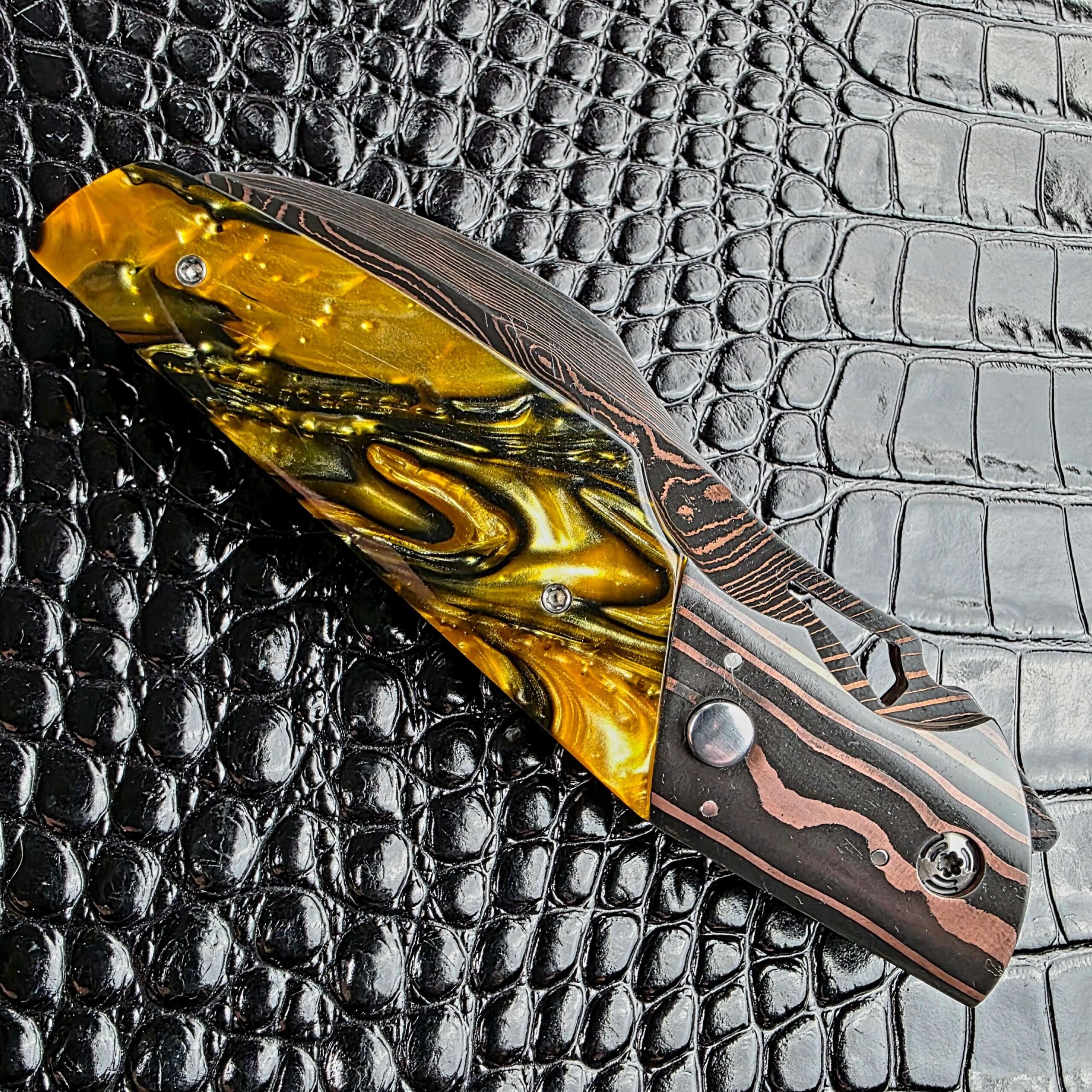 Closed Reese Weiland Harpy on its show side, with the firing button in the Copper Damascus bolster