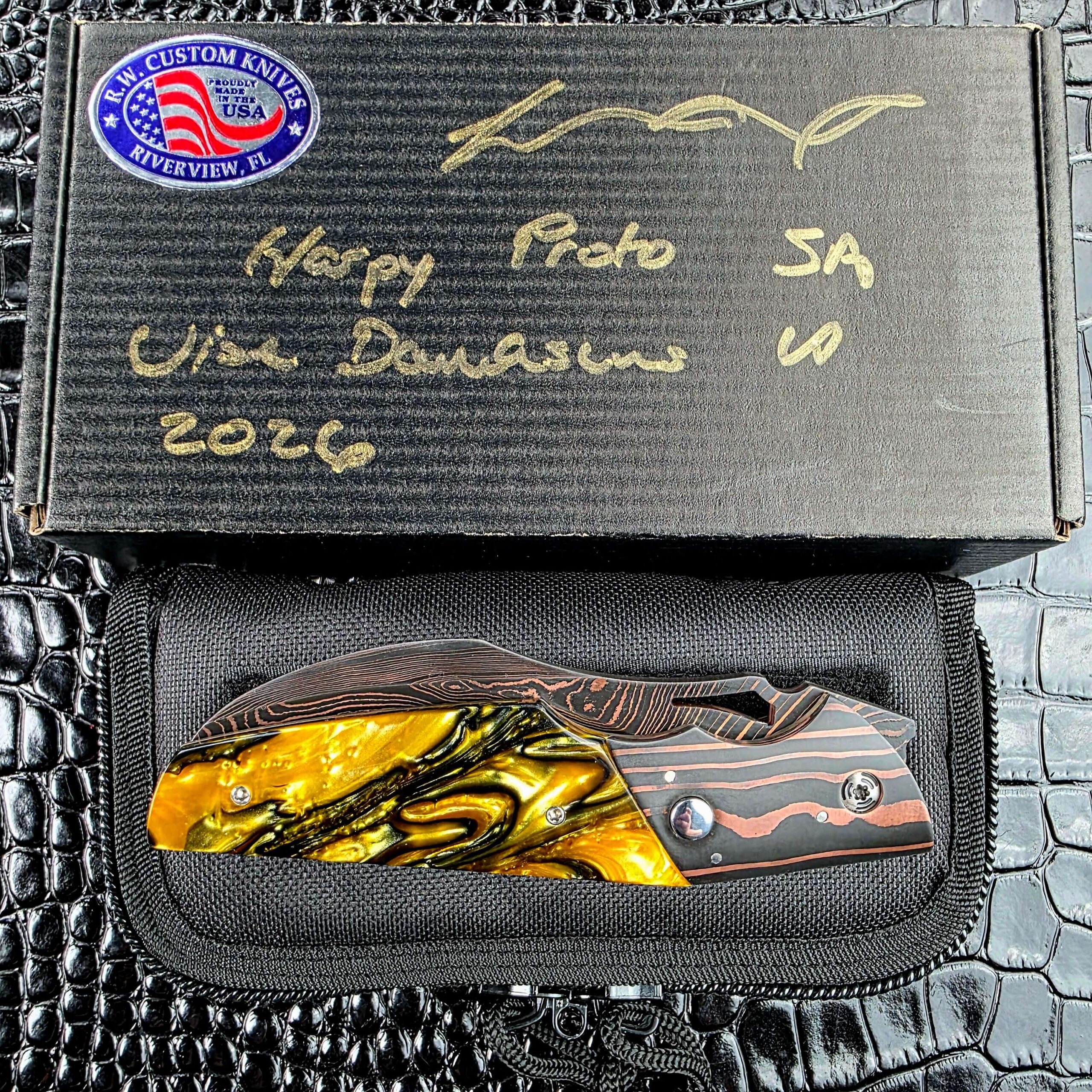 Reese Weiland Harpy closed in its zippered pouch below the signed R.W. Custom Knives box labeled Harpy Proto SA