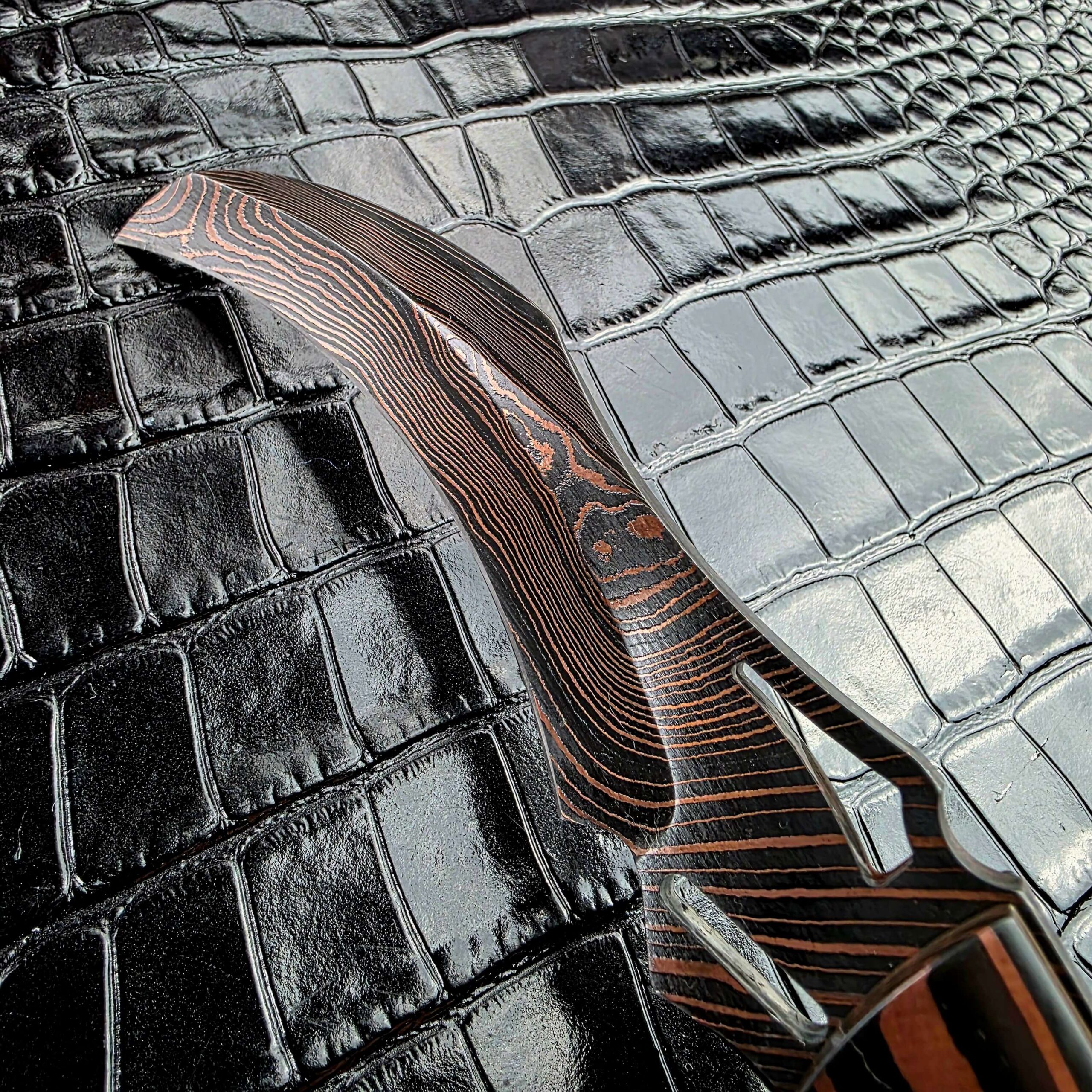 Brad Vice Copper Damascus hawkbill blade of the Reese Weiland Harpy, with Copper lines flowing through the steel