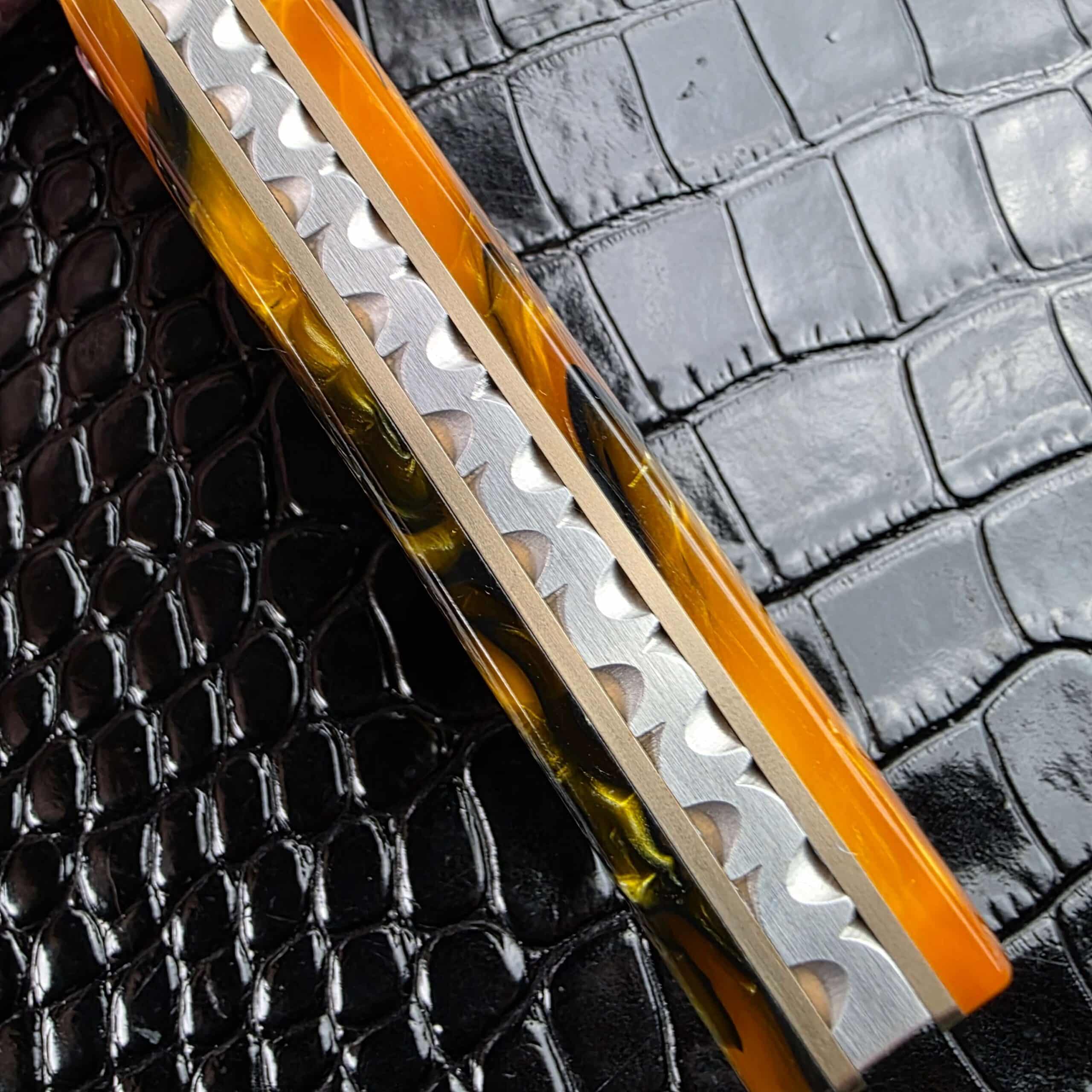 Spine view of the Reese Weiland Harpy showing the hand-filed, sculpted backspacer between the acrylic scales