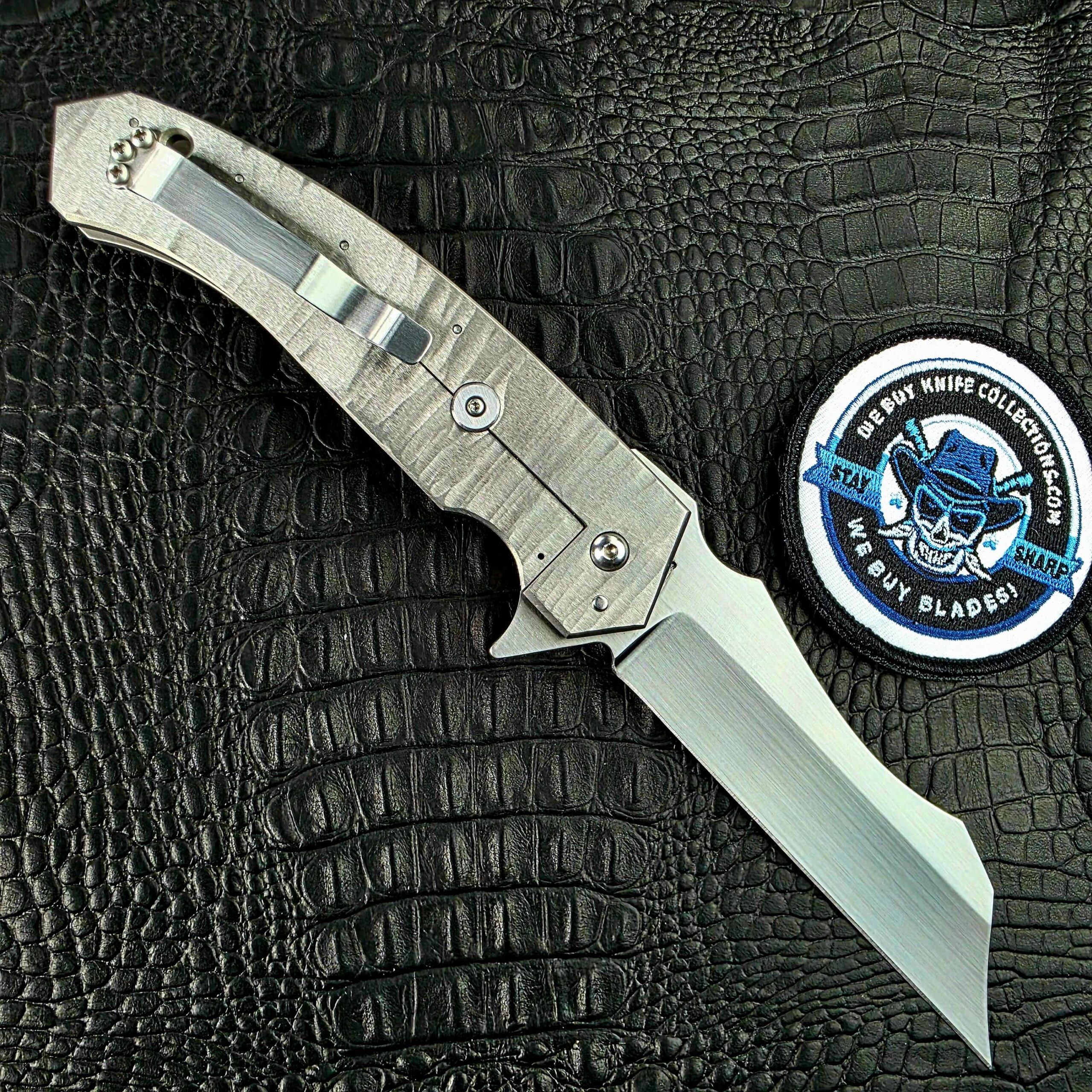 Reese Weiland Strike Prototype 2 in full profile, open on its show side, with the We Buy Knife Collections patch